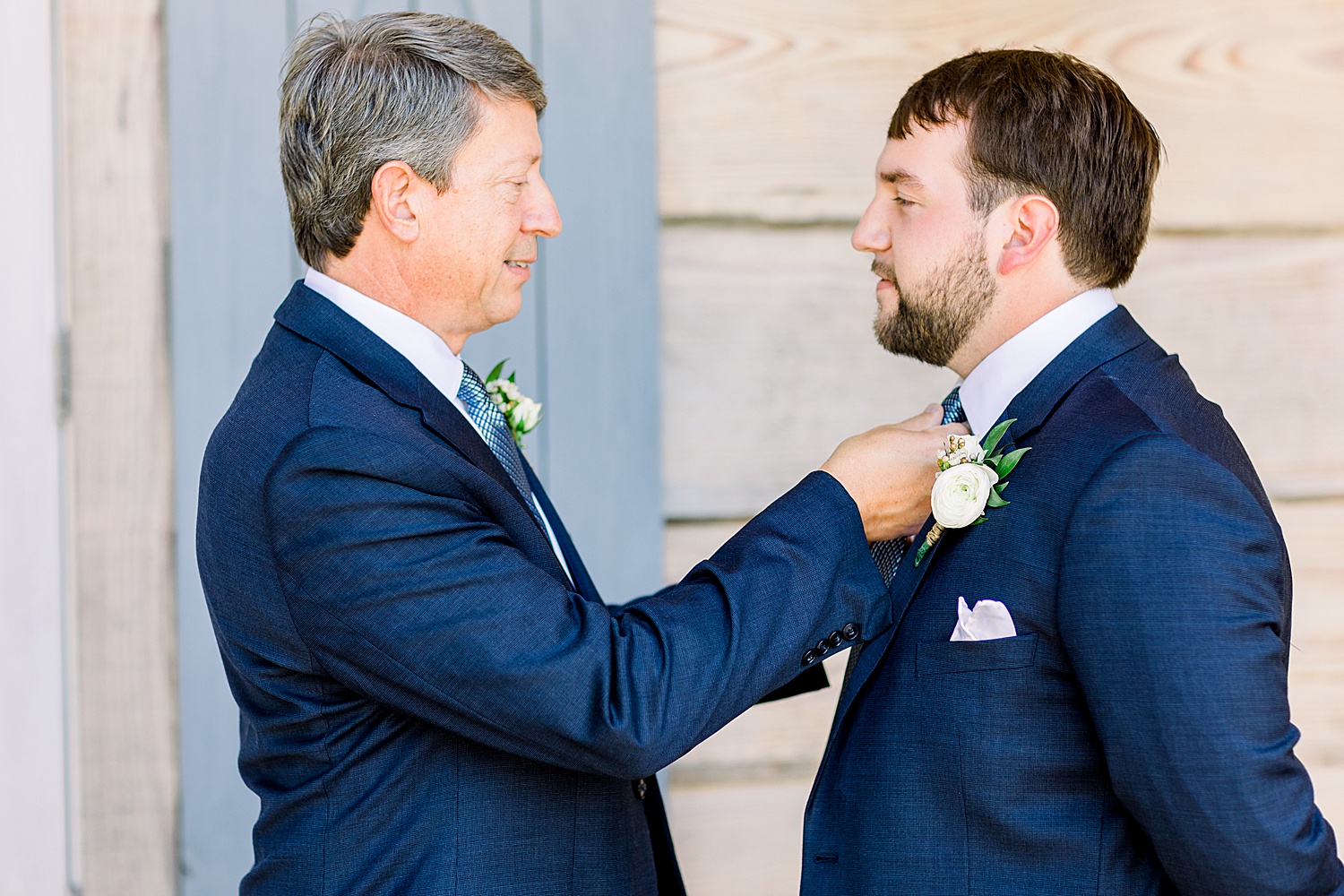 father of the groom helping Groom with tie