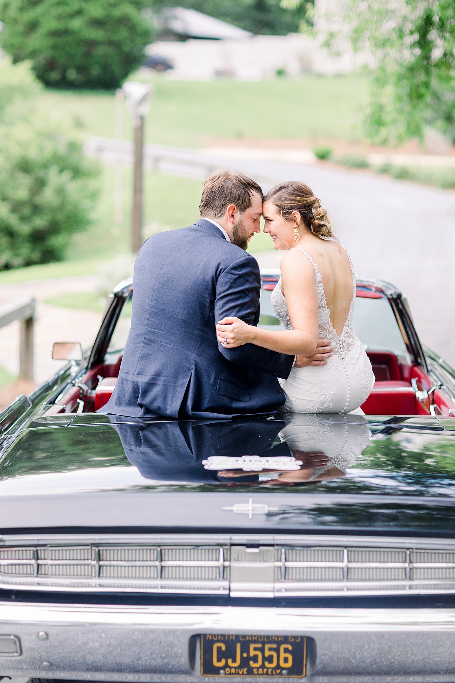 newlyweds sit on classic car from Coats Cars