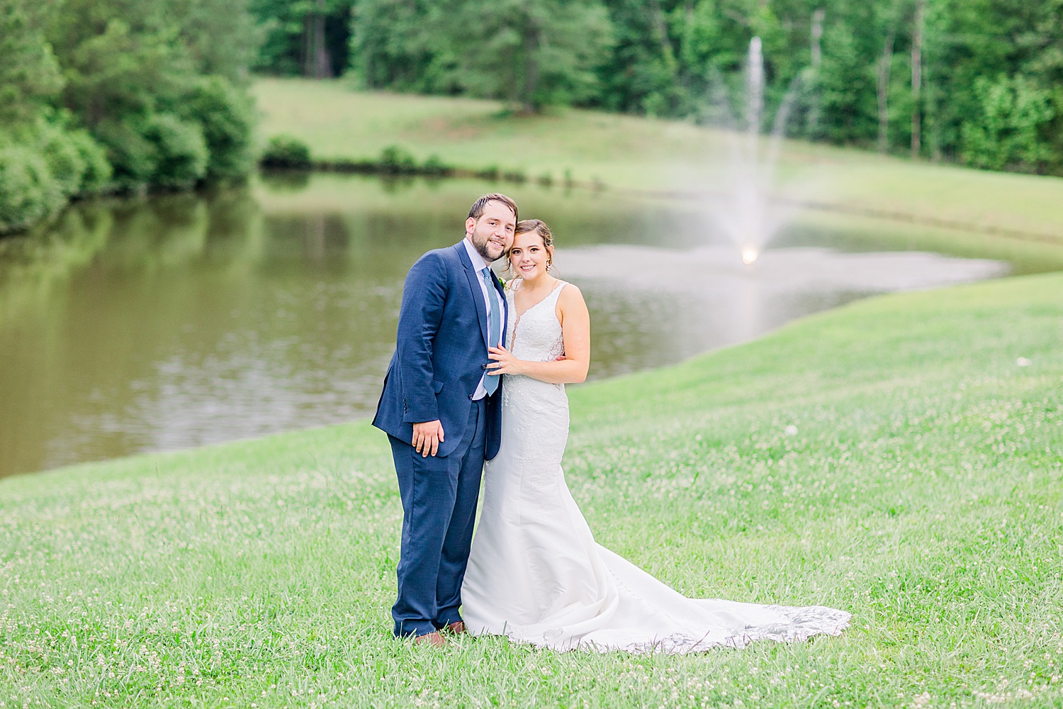 Newlyweds stand by pond at Belle Farms in Sterrett Alabama
