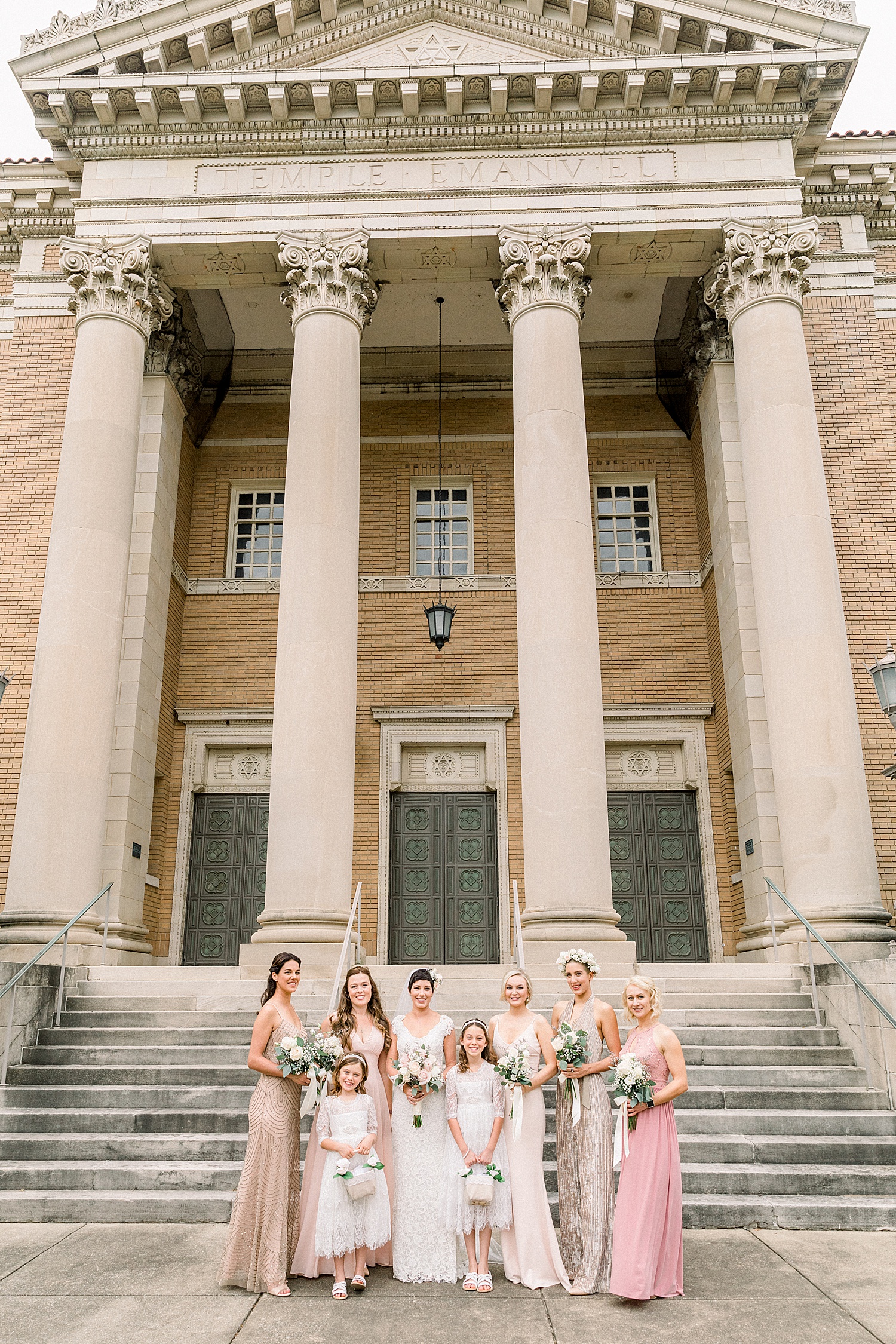 bride + bridesmaids stand on the steps of Temple Emanuel in AL