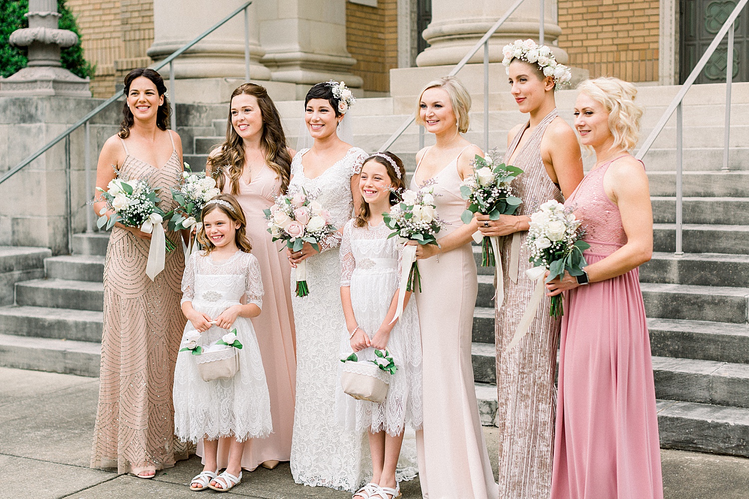 bridesmaids + flower girls stand around bride outside Temple Emanuel