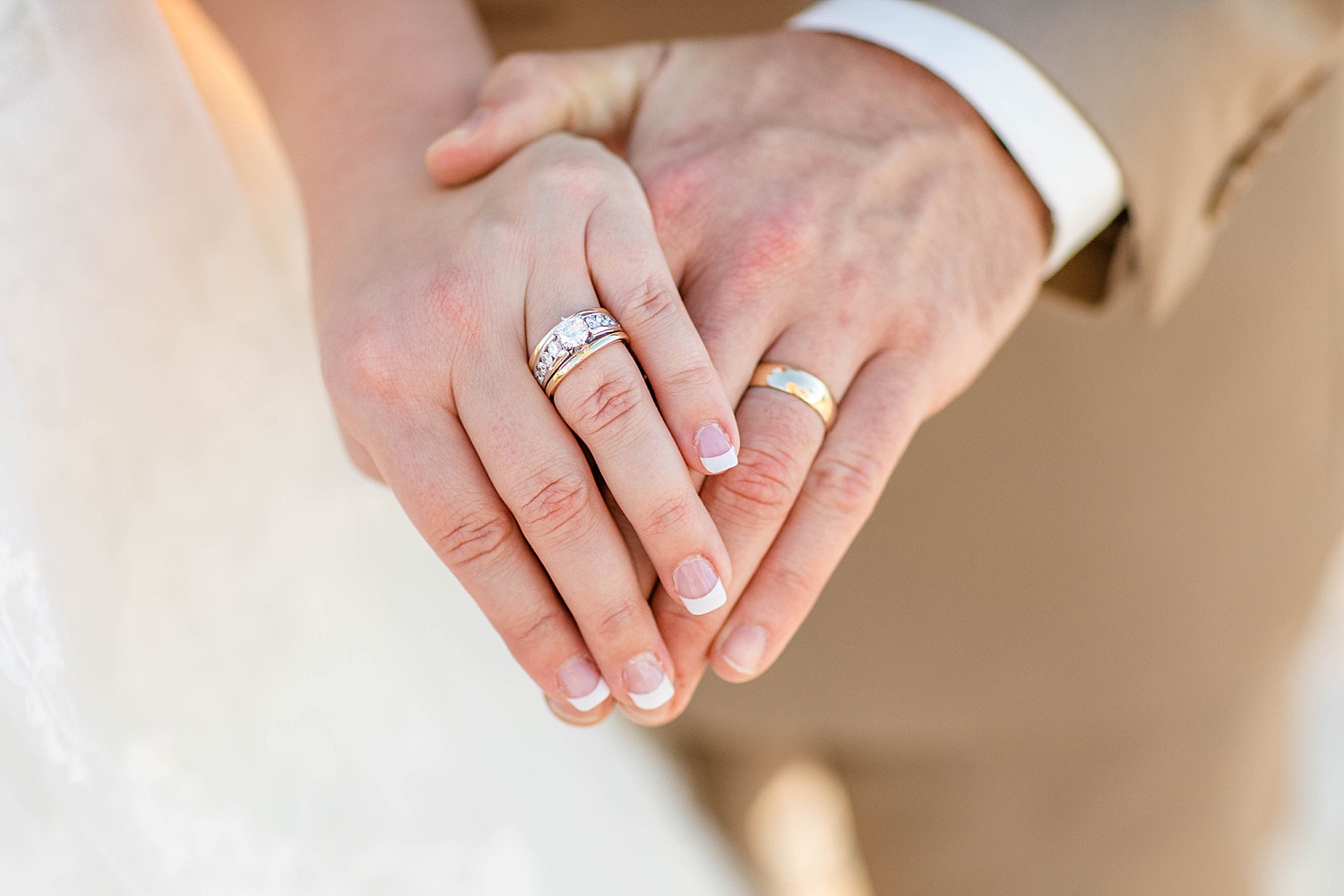 husband and wife hold hands and show off wedding bands