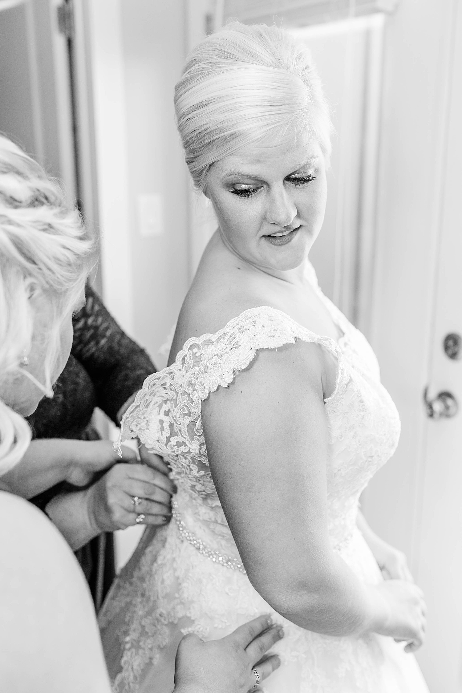 bride getting the back of her dress buttoned up