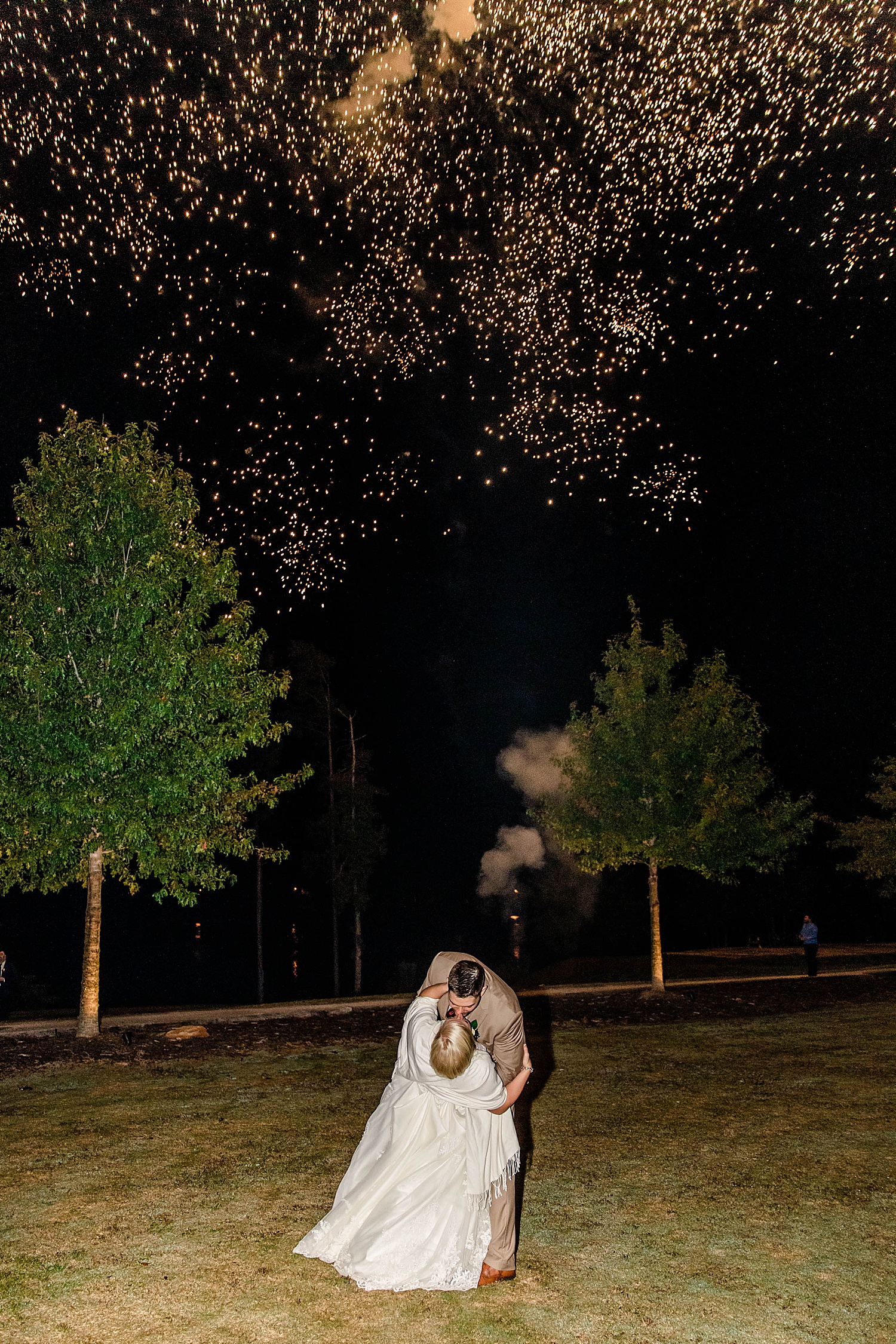 groom kisses bride watching fireworks