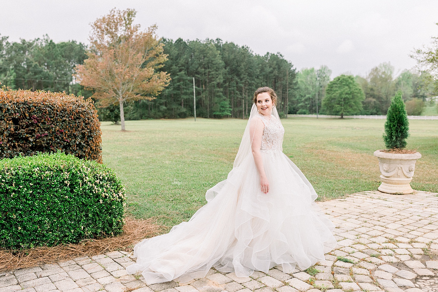 bride stands on cobblestone on the grounds of Tangarray wedding venue