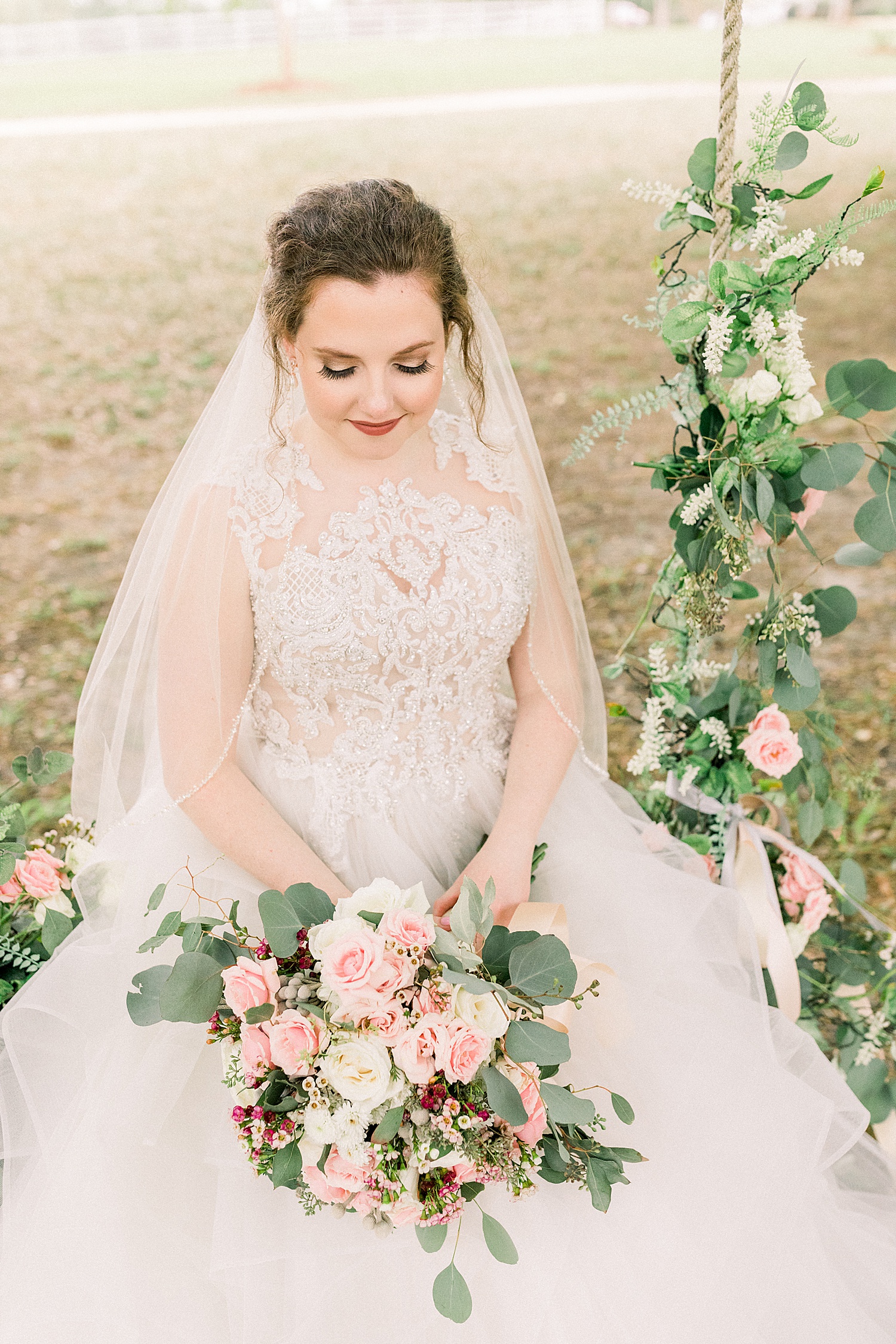 bride details as she sits on swing hanging from tree