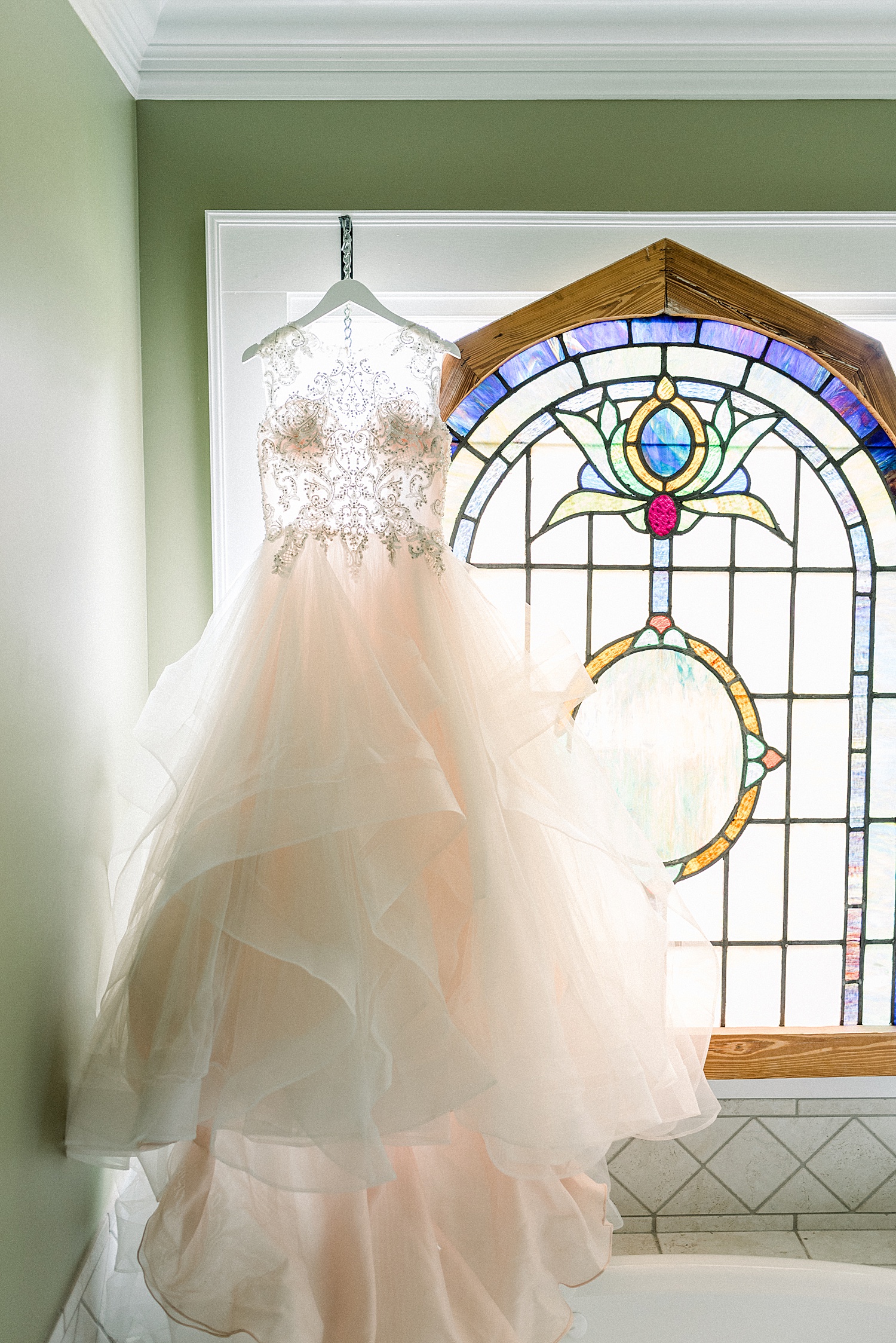 Bride hanging by stained glass window