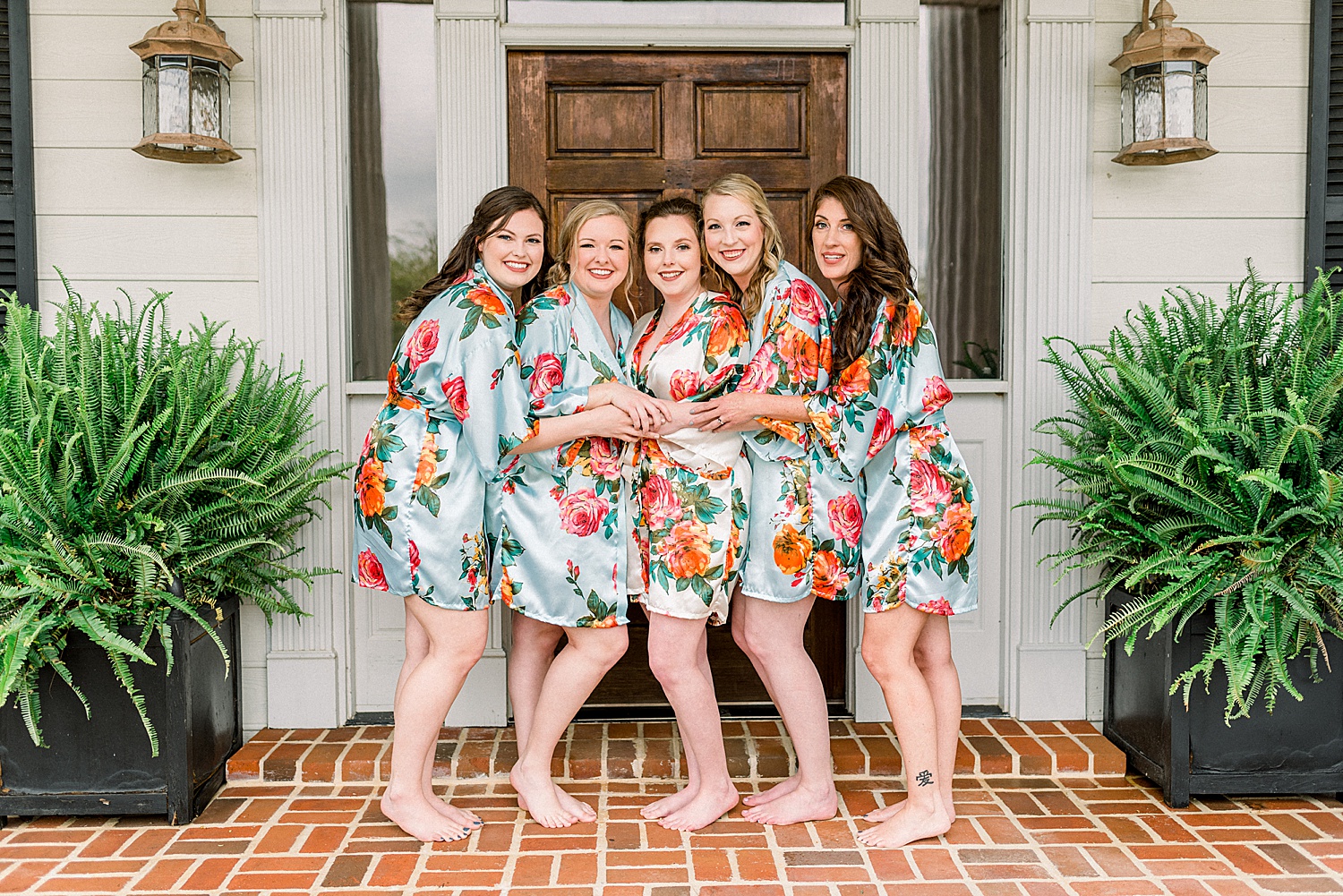 bridesmaids in matching floral robes getting ready for AL wedding