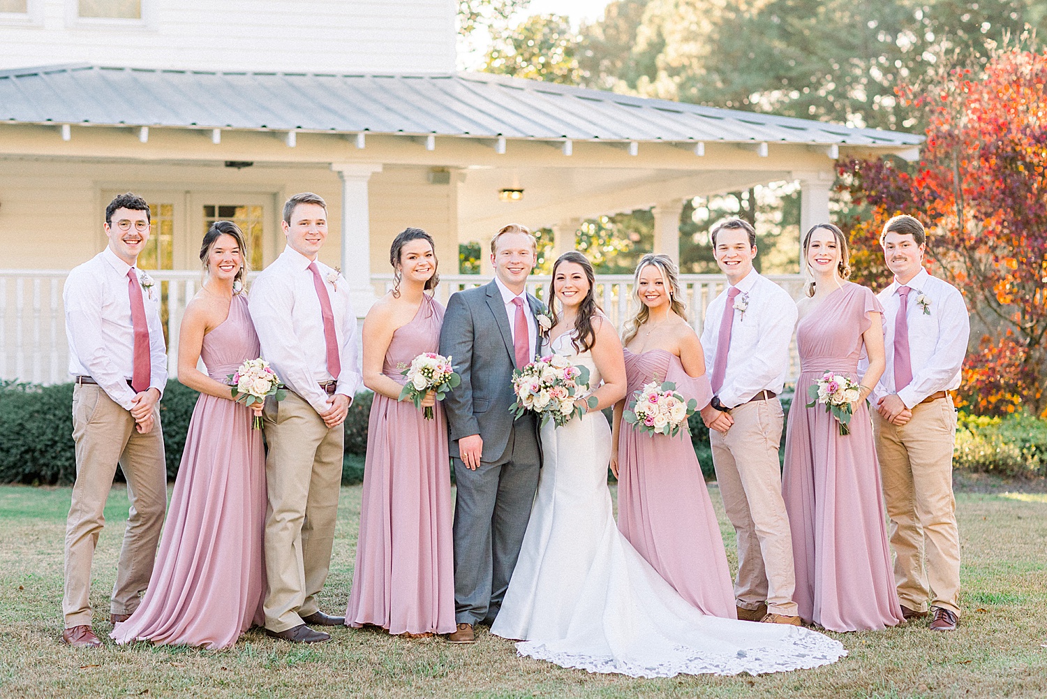 newlyweds stand with their bridal party outside wedding venue