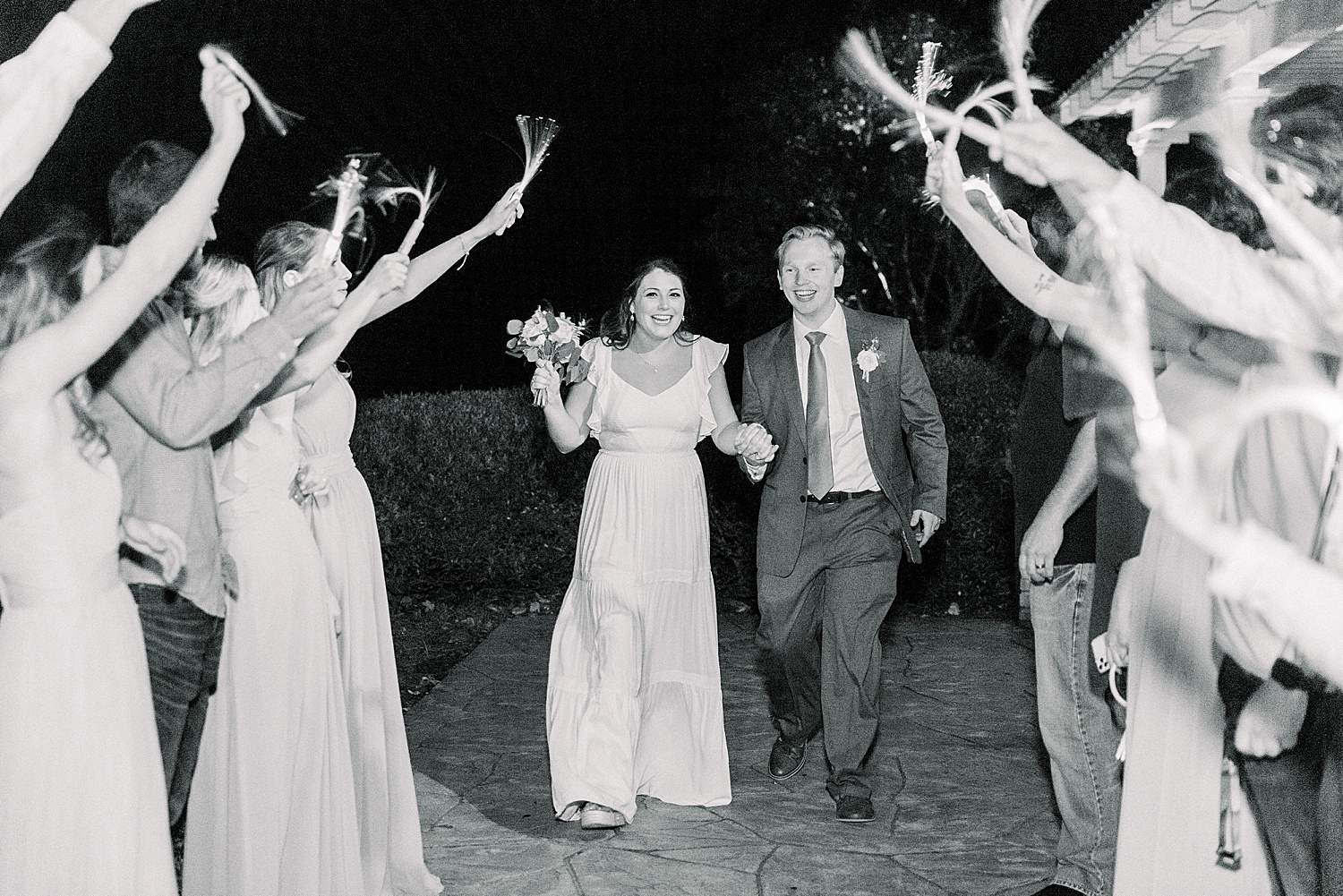 wedding guests cheer for husband and wife at the end of the night