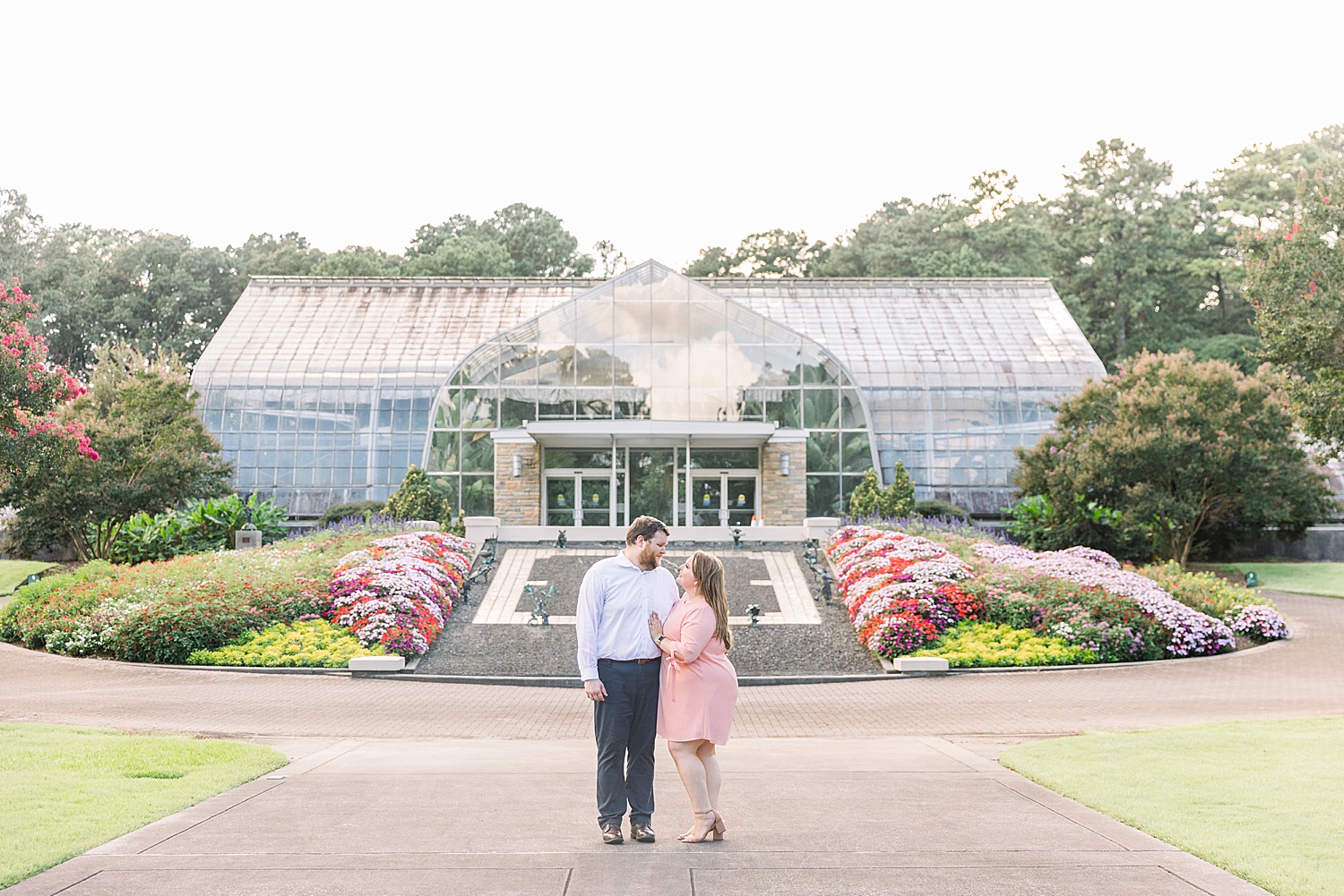 engaged couple stands in front of Birmingham Botanical Gardens