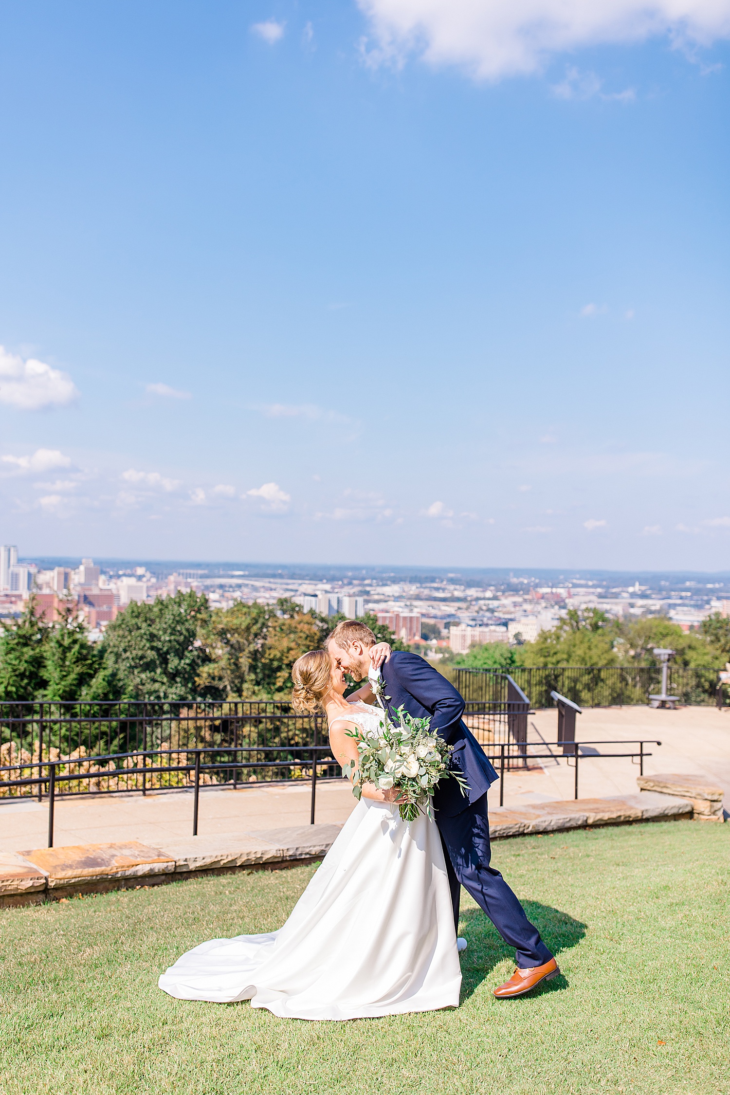 bride and groom kiss with the amazing city view in the background
