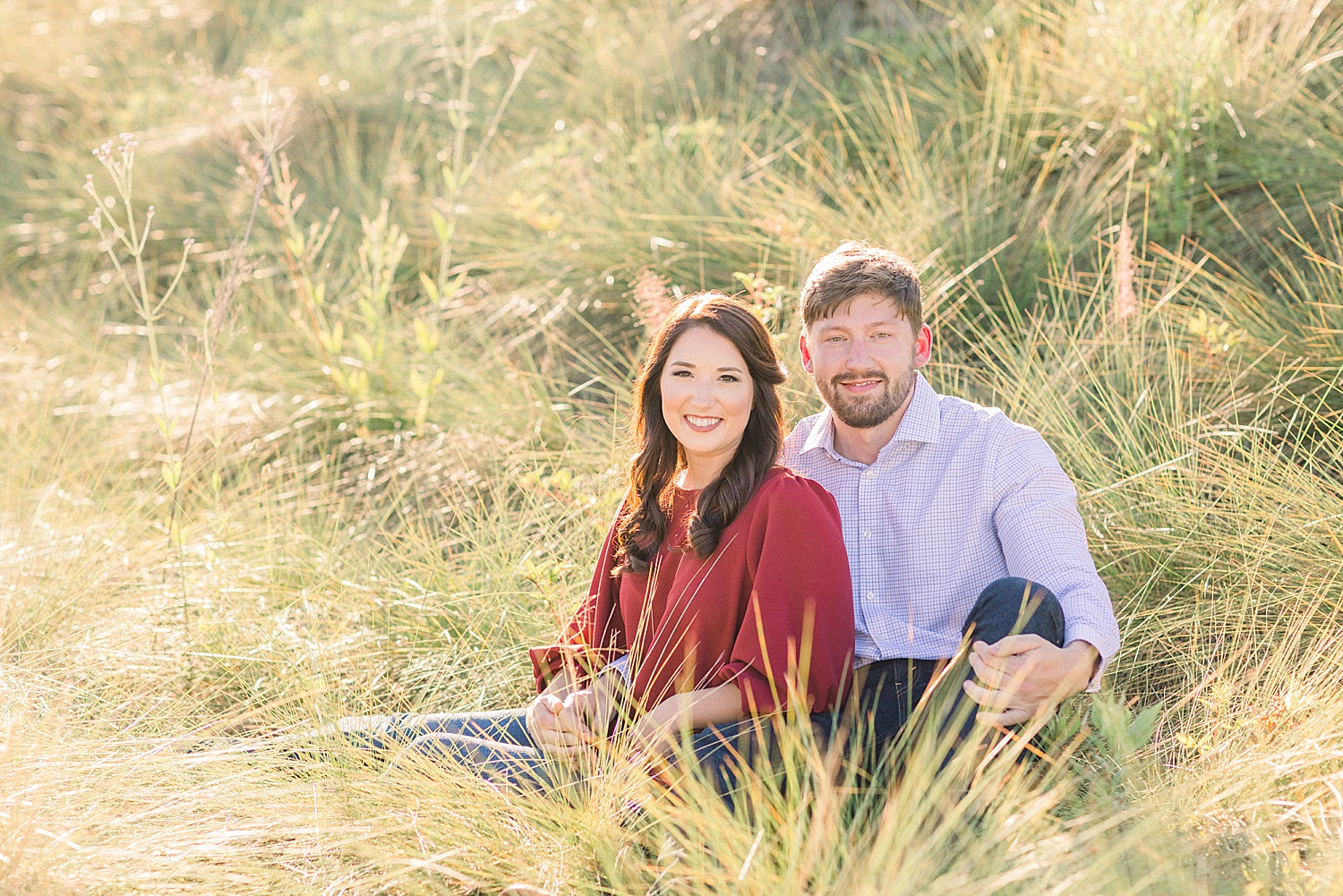 couple sitting in tall grass at Railroad Park