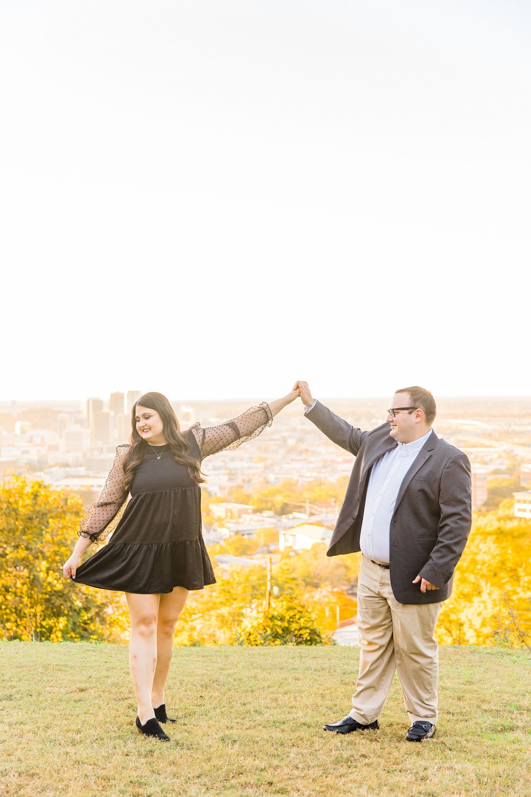 A Year of Birmingham Alabama Engagement Sessions couple on rooftop over Birmingham AL skyline
