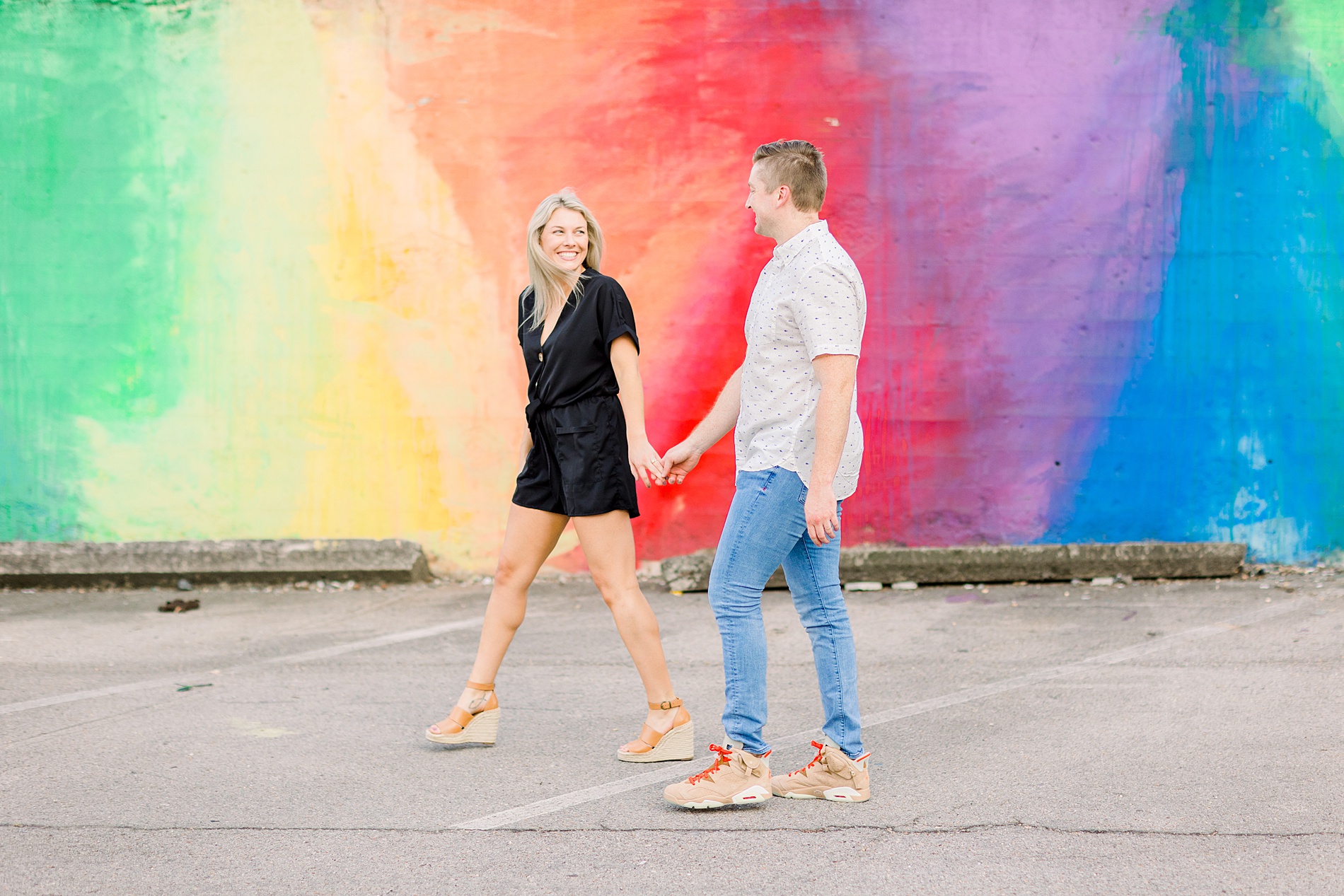 couple walk in front of rainbow art wall -A Year of Birmingham Alabama Engagement Sessions: 2021