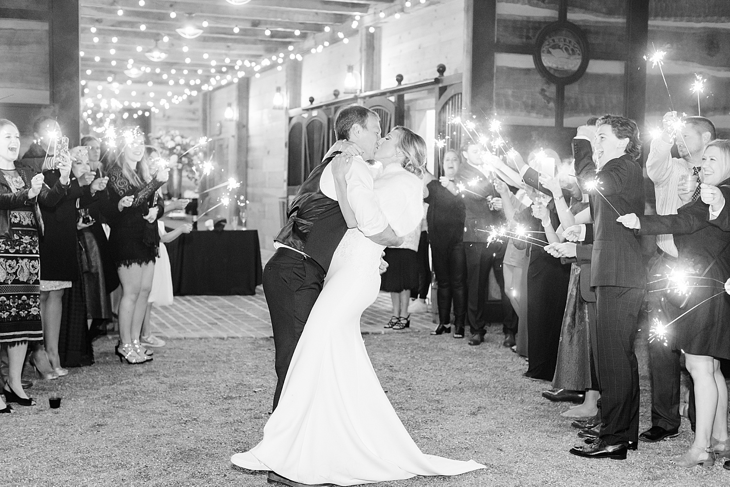 newlyweds at the end of the night with wedding guests holding sparklers