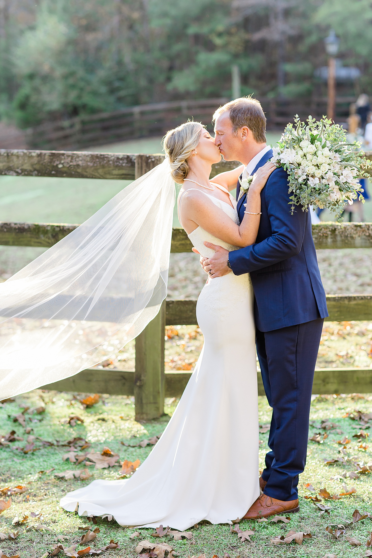 newlyweds kiss by fence during AL wedding