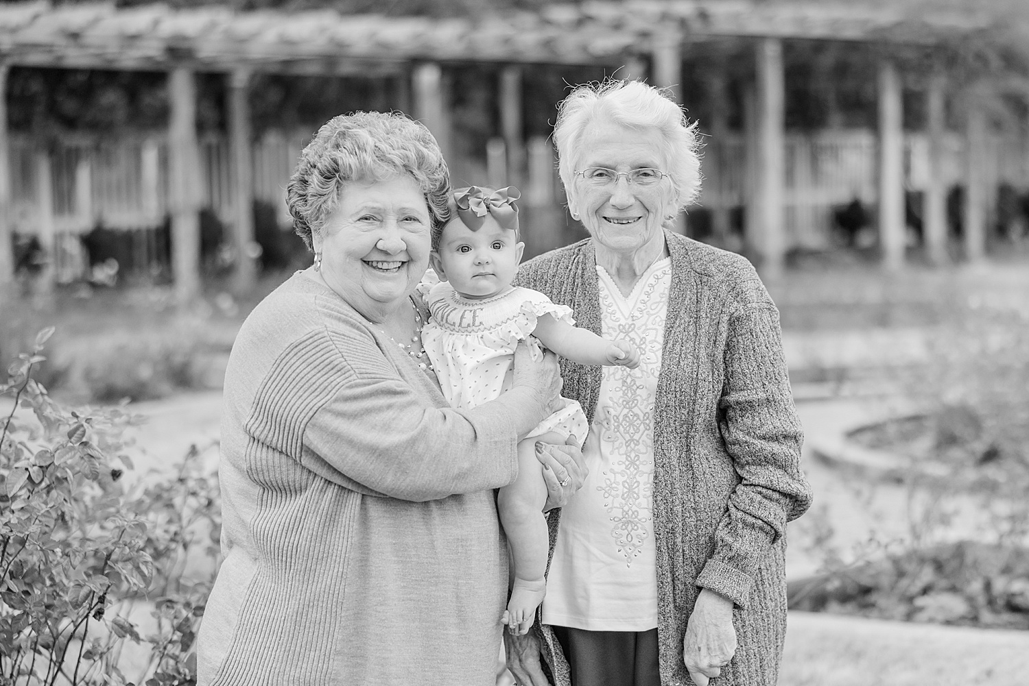 6 month old little girl held by her two great grandmas at the Birmingham Botanical Gardens