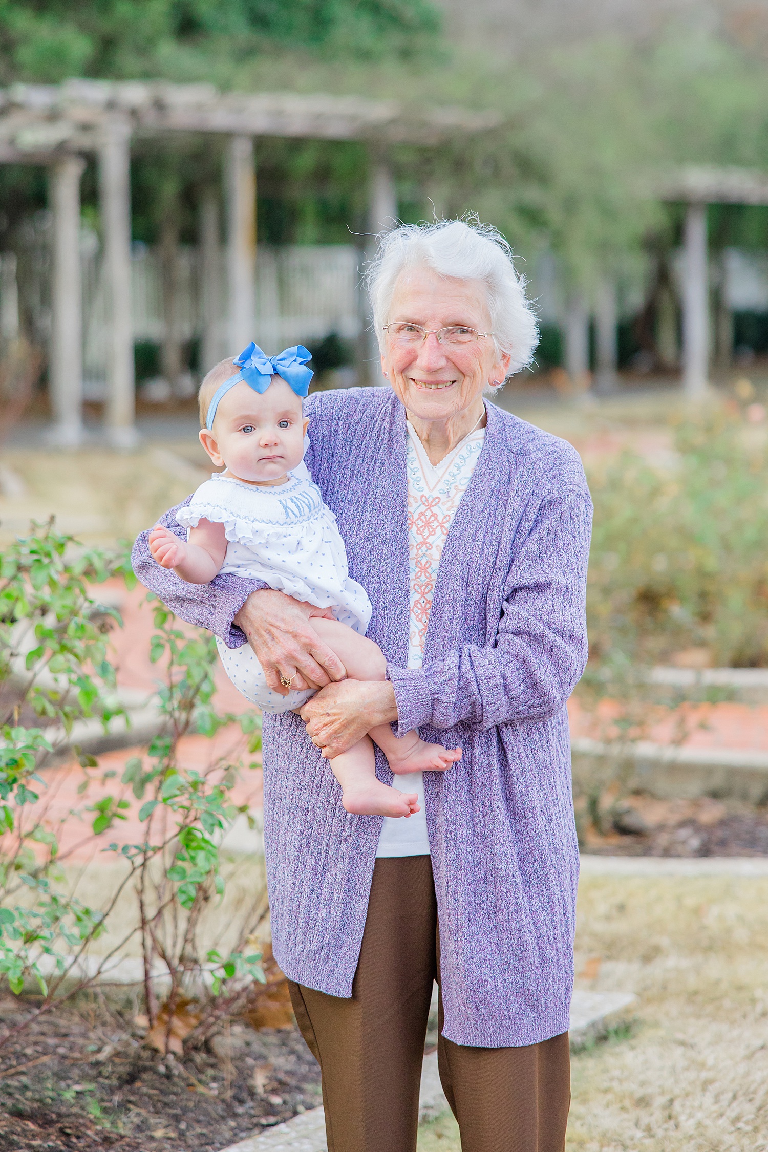 great grandma holds her 6 month old granddaughter at Birmingham Botanical Gardens