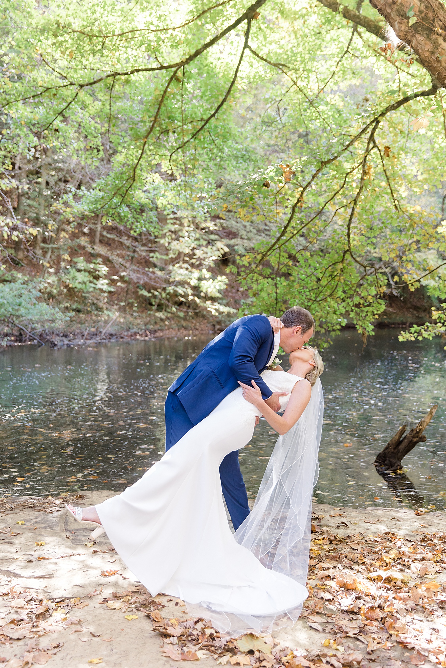 husband dips his bride before Swann Lake Stables Wedding