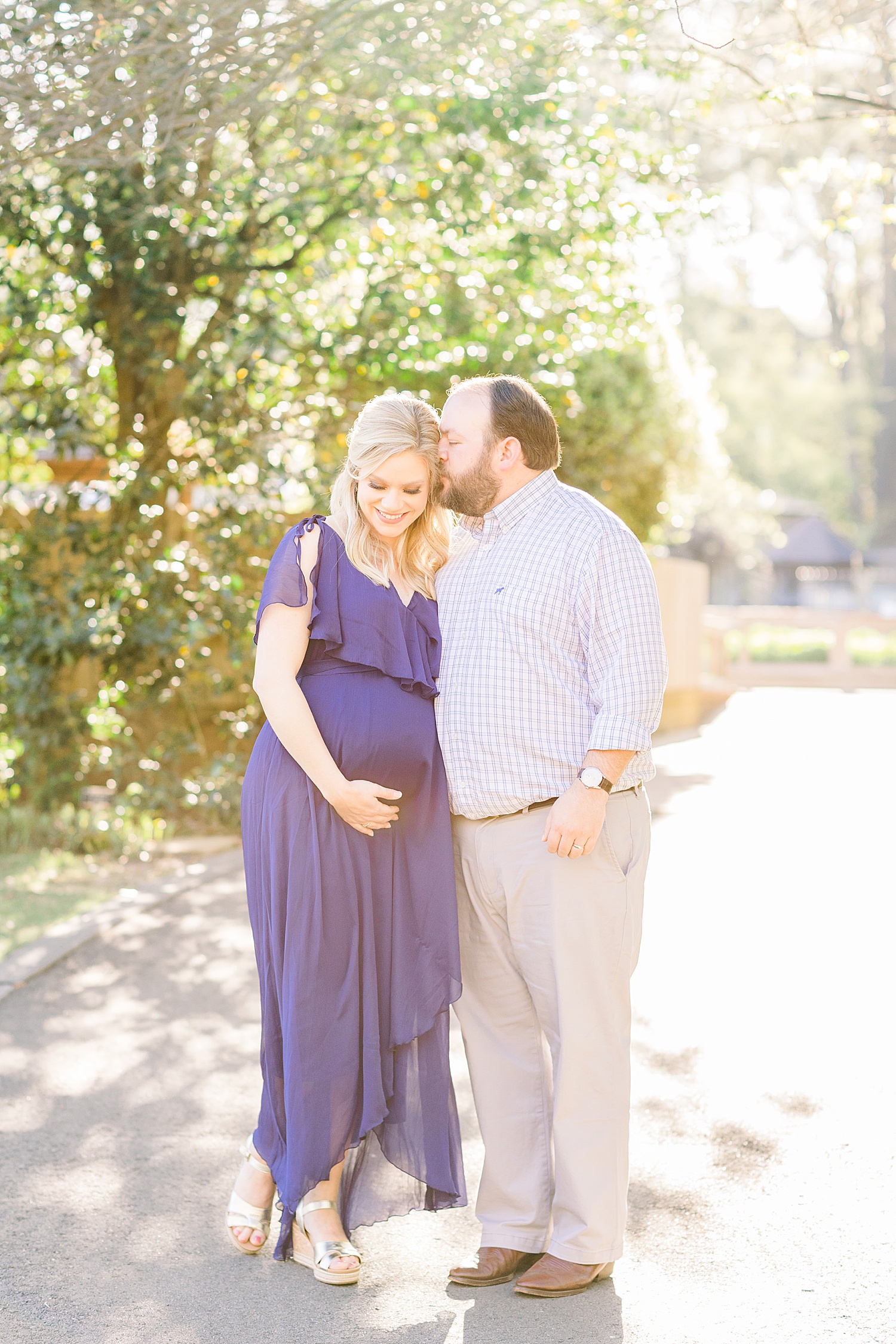 expectant mom in royal blue dress with her husband