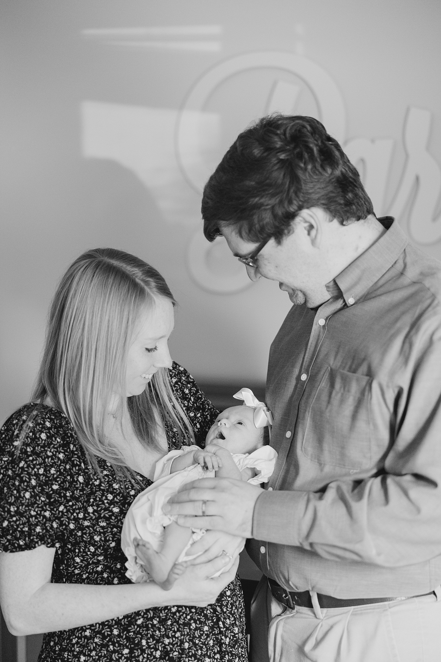 mom and dad look down on newborn girl