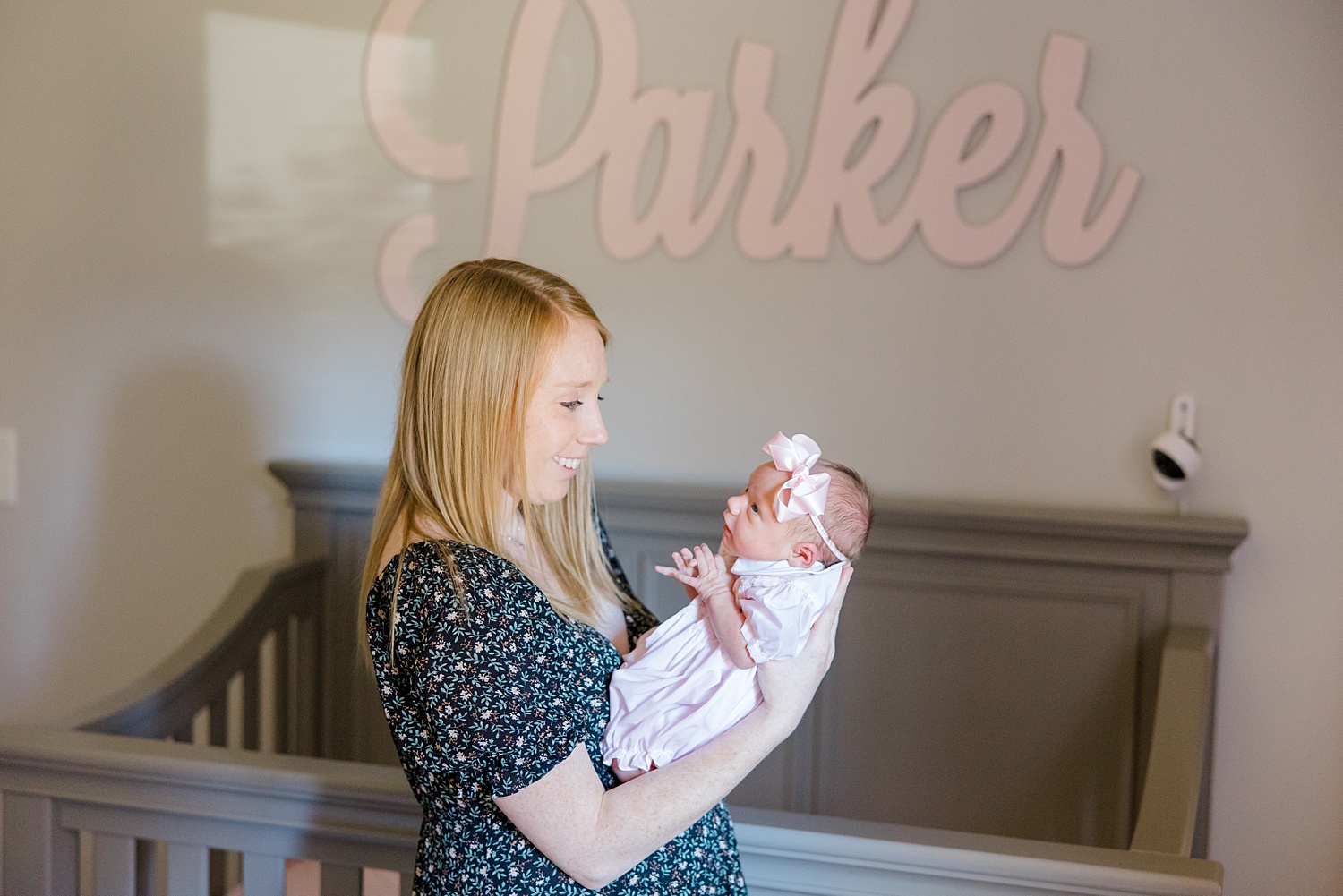 Mom holds newborn girl in nursery