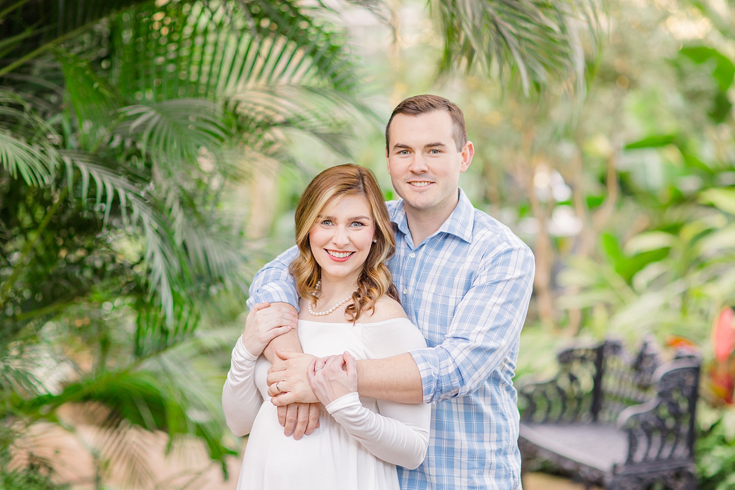 husband wraps his arms around wife during Birmingham Alabama Maternity Portraits at the Botanical Gardens