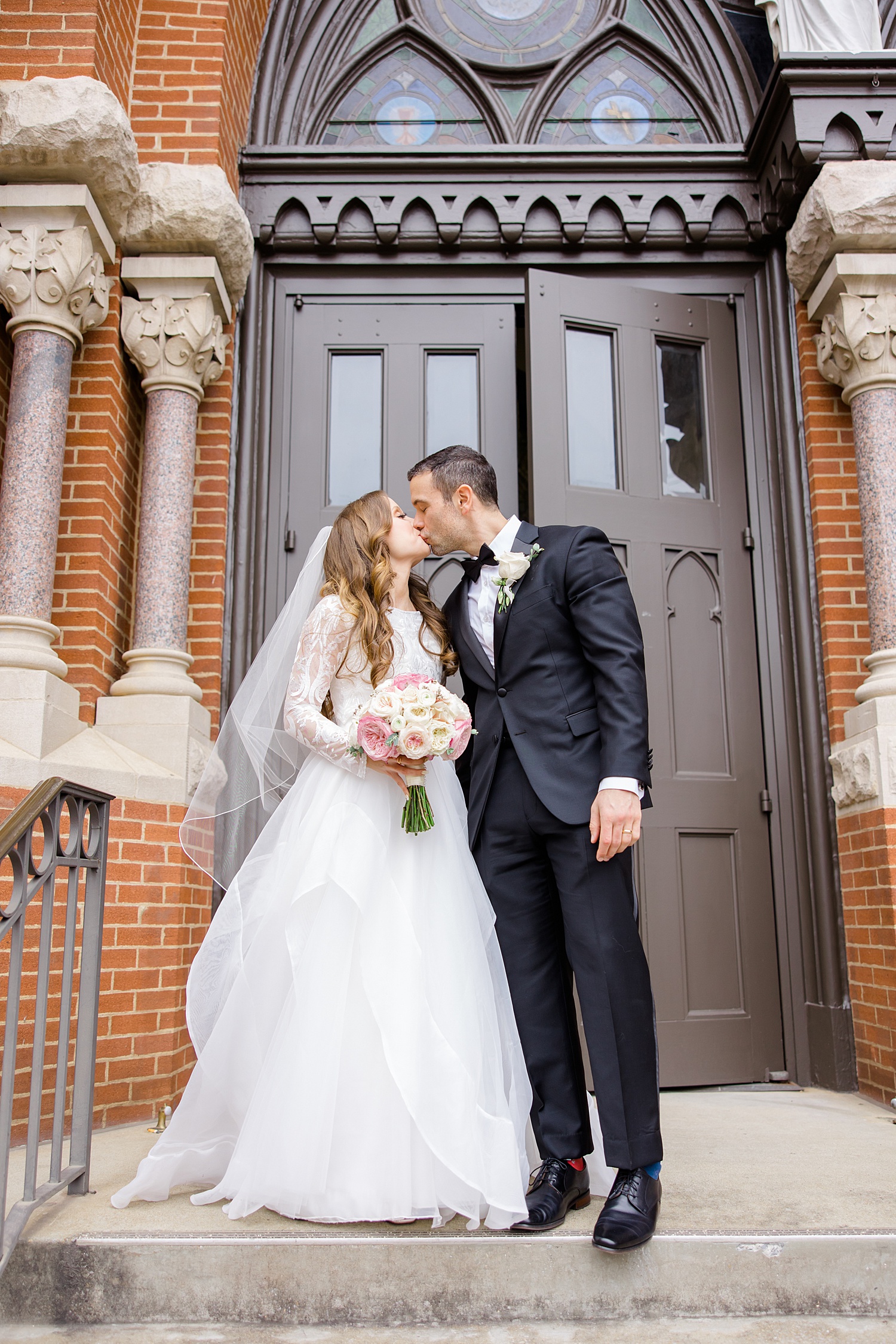 newlyweds kiss outside doors of church