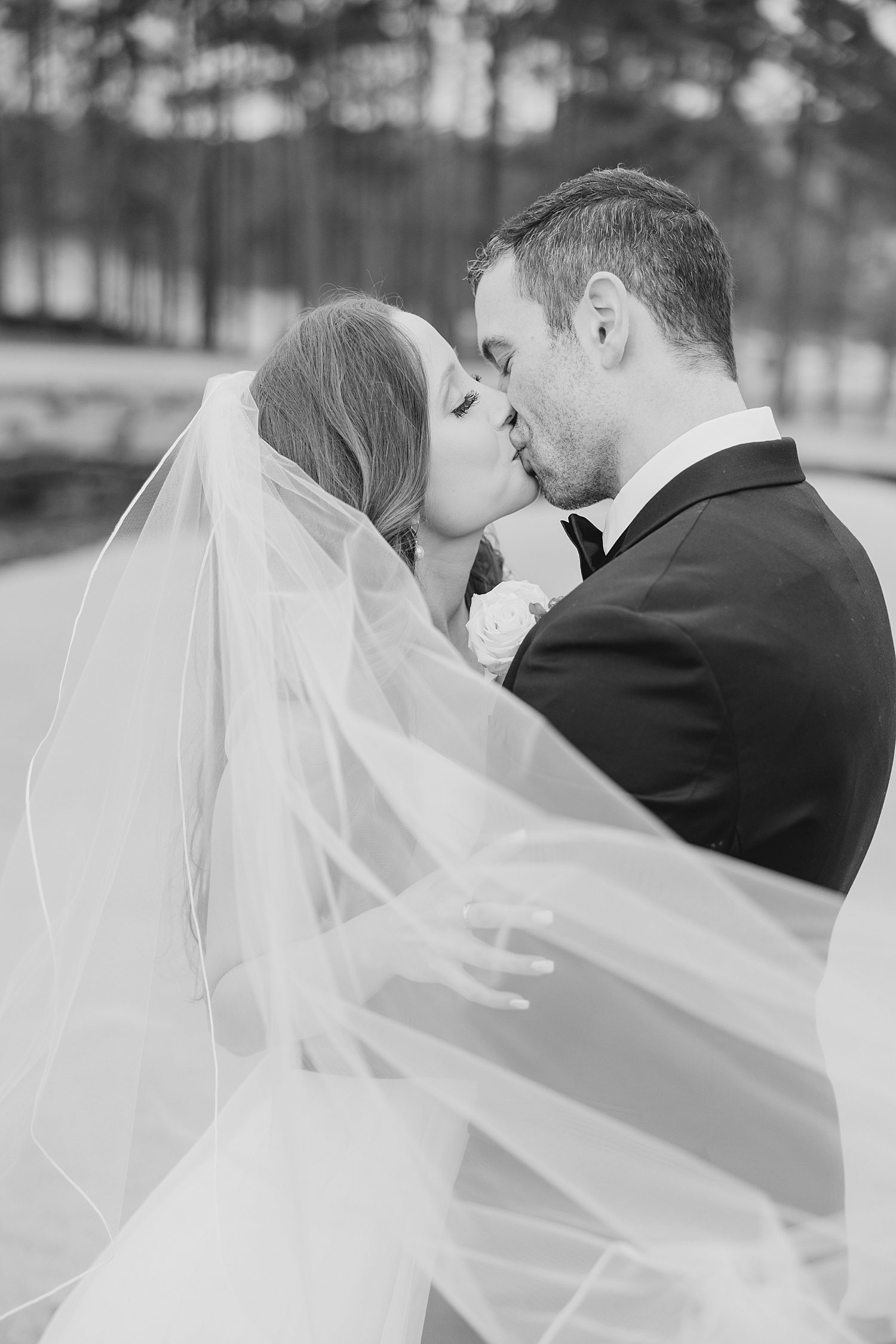 newlyweds kiss during wedding portraits
