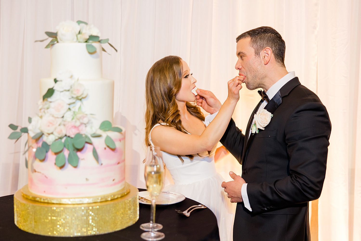 bride and groom feed each other wedding cake