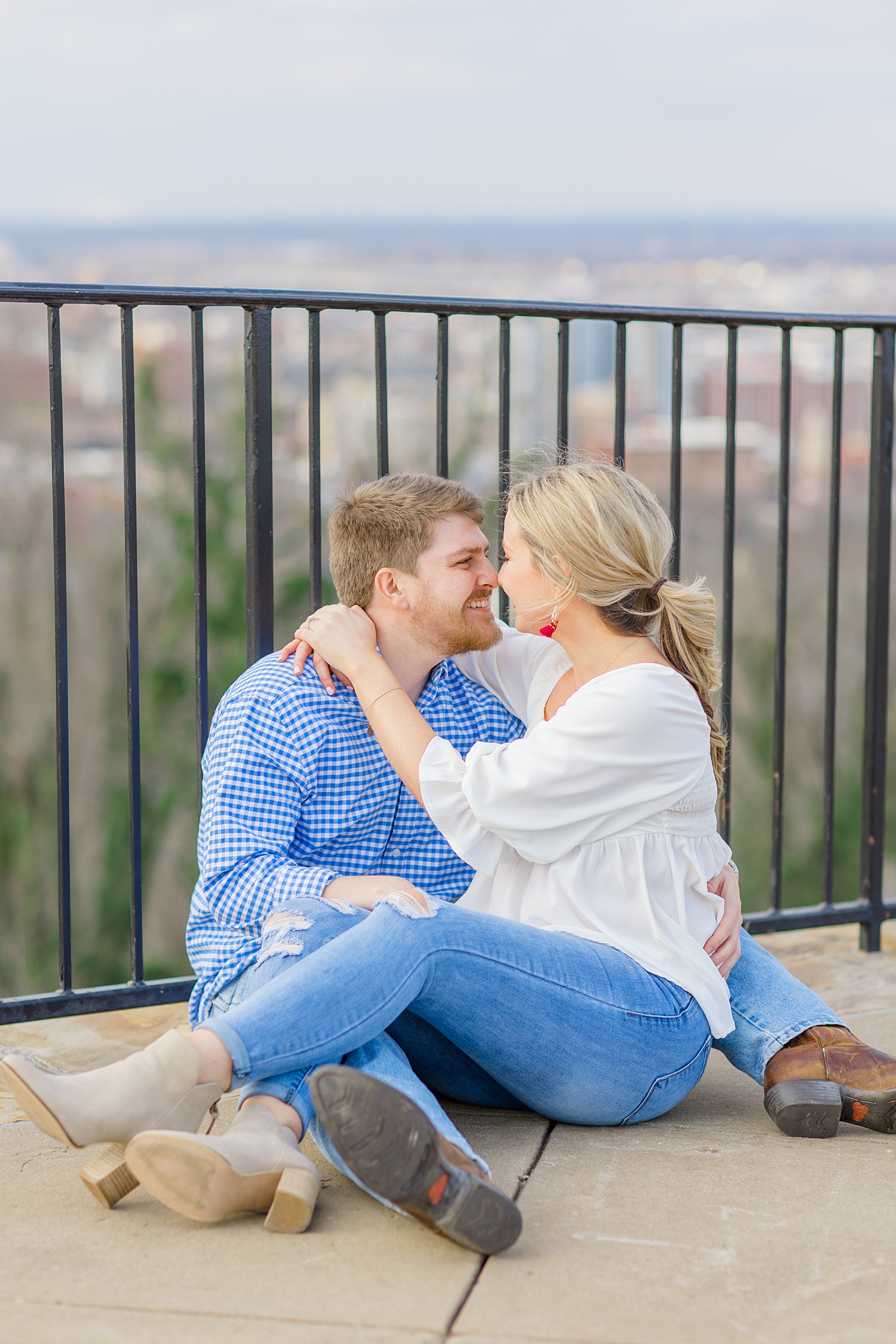 woman sits on fiance's lap during engagement portaits