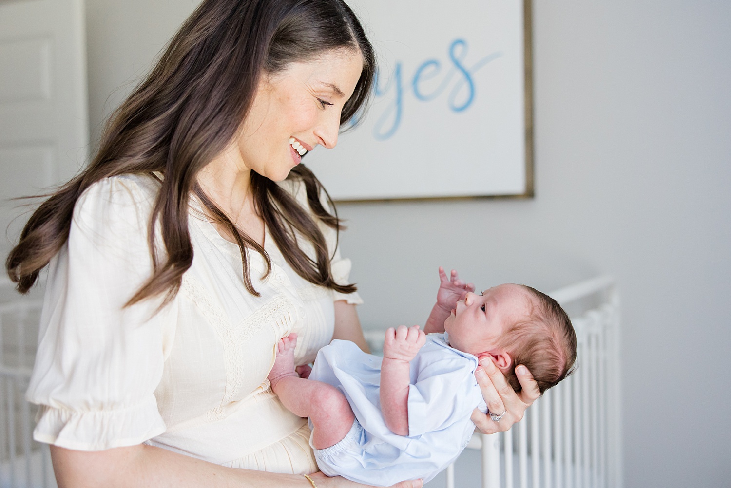 mom smiles as she looks at her newborn son