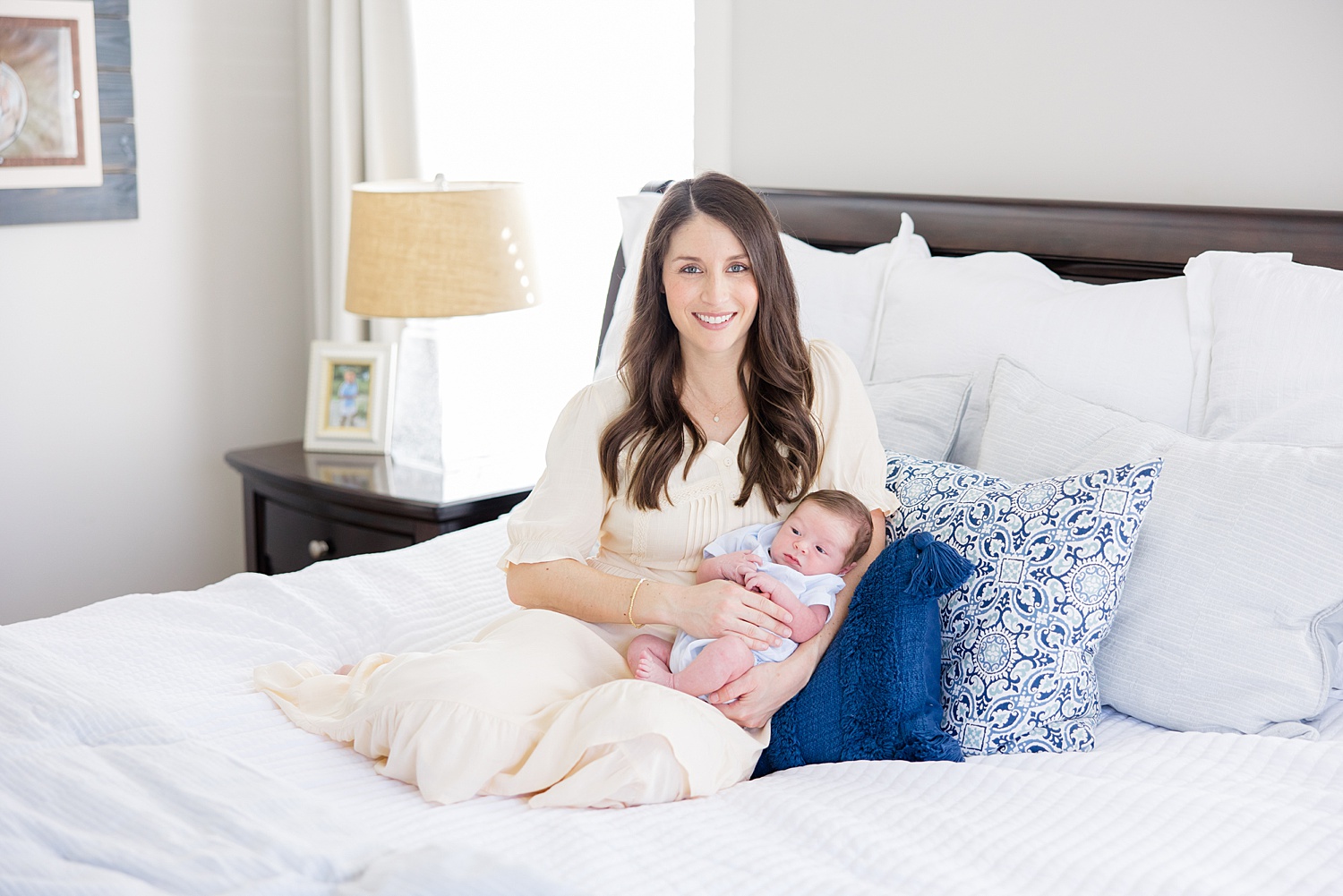 mom and baby boy on bed with blue pillows