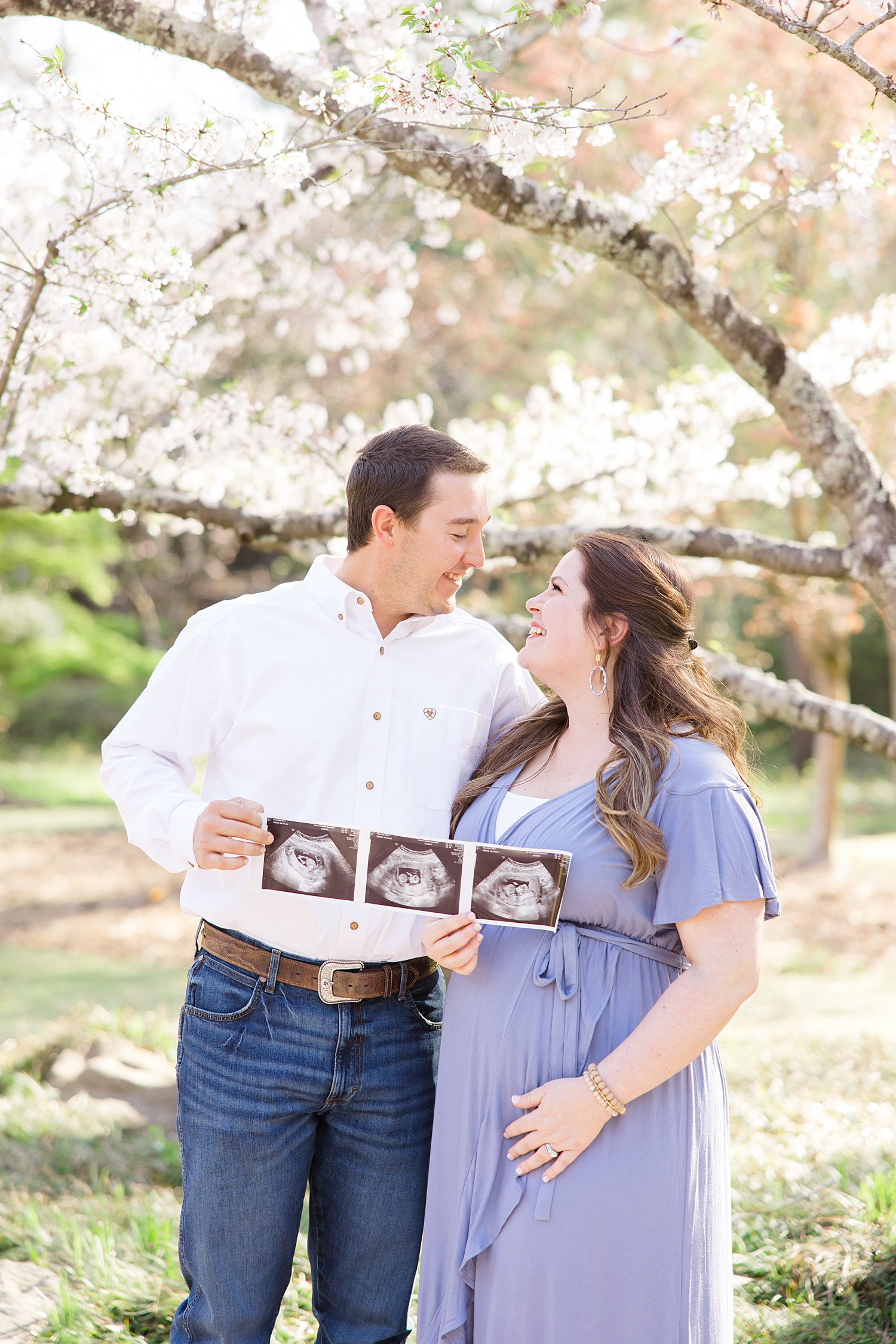 expectant couple hold up ultrasound photos