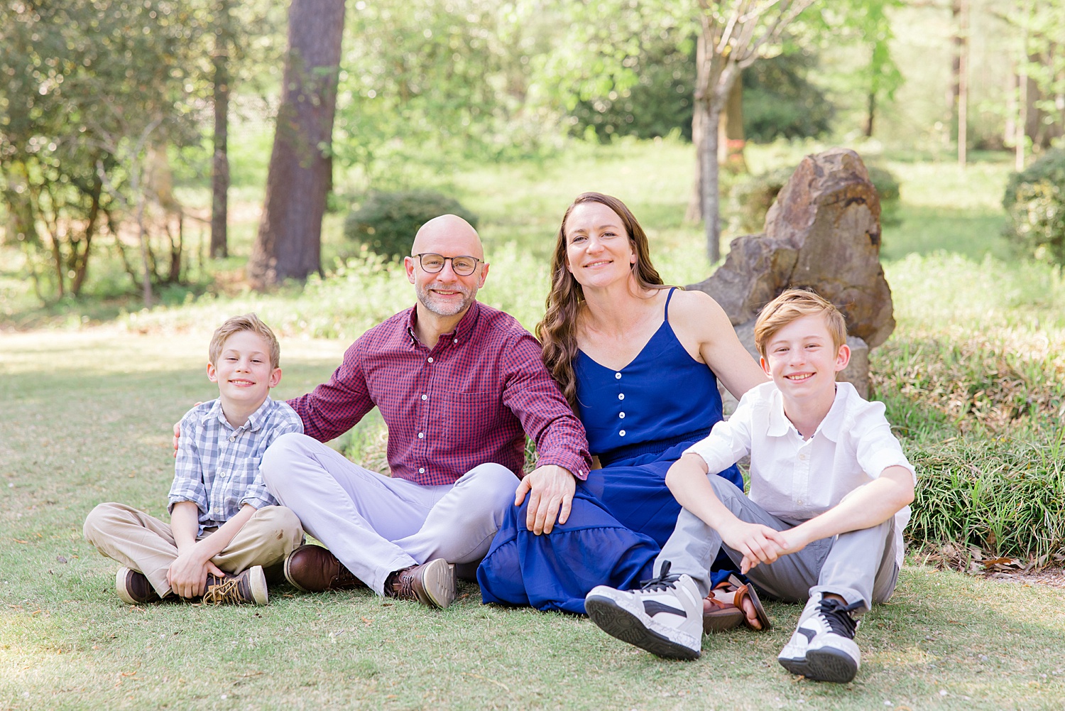 family of four sit in the grass for spring mini session