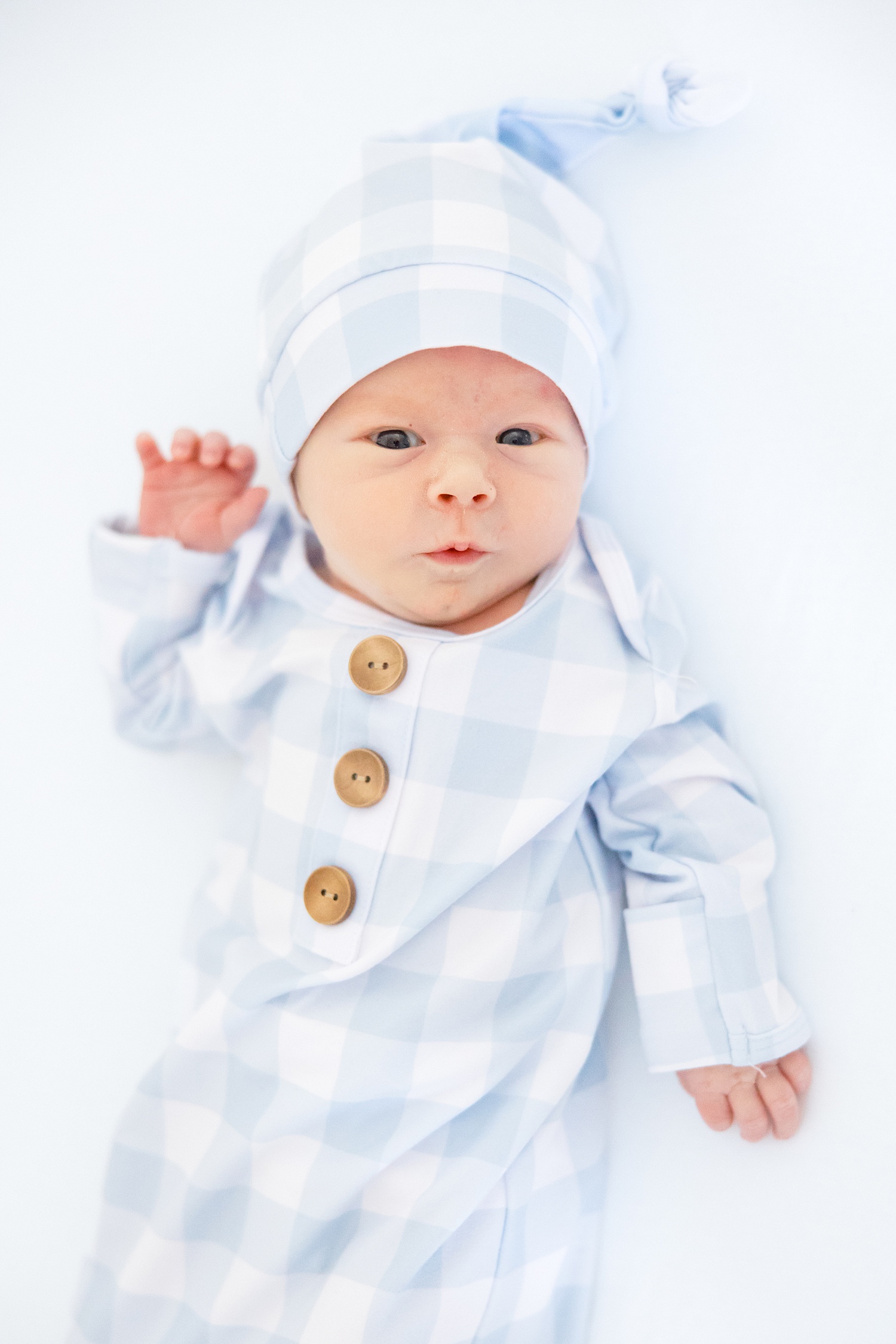 wide awake newborn in blue checkered outfit