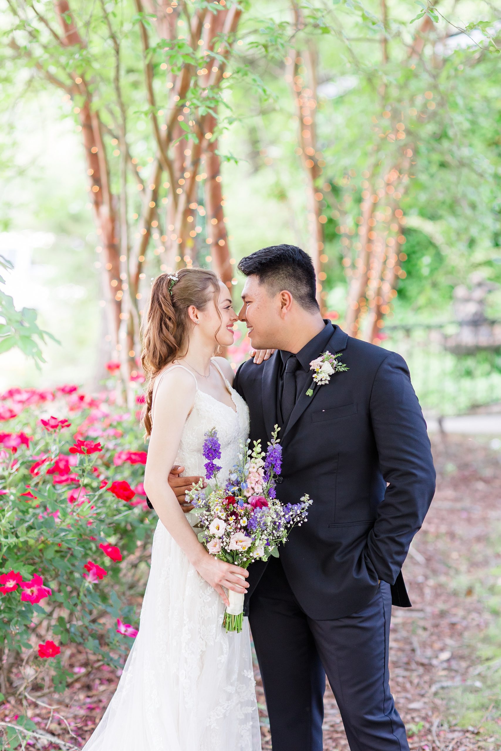 bride and groom in front of beautiful garden flowers 