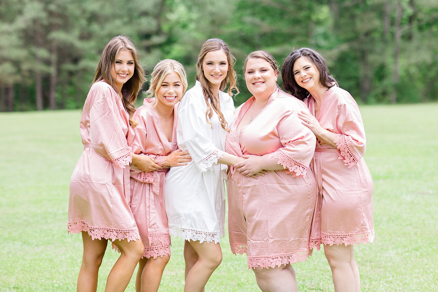 bride and bridesmaids in matching blush pink robes