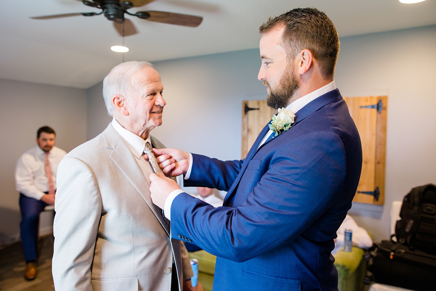 groom helps father of the bride with tie