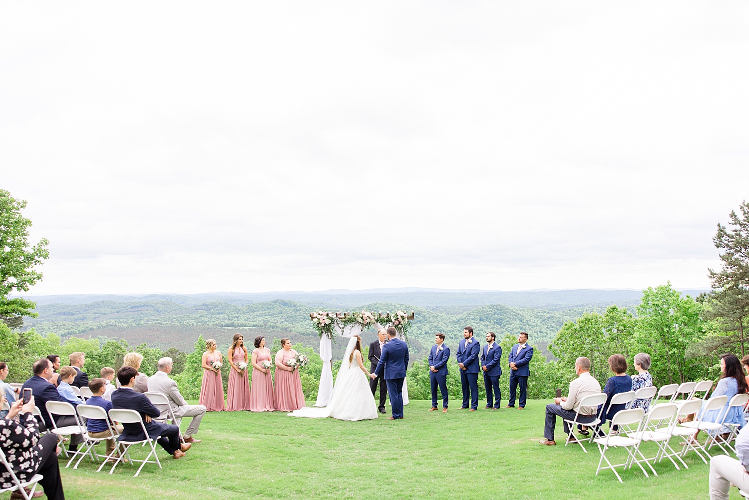 picturesque wedding ceremony on top of a hill overlooking a valley below