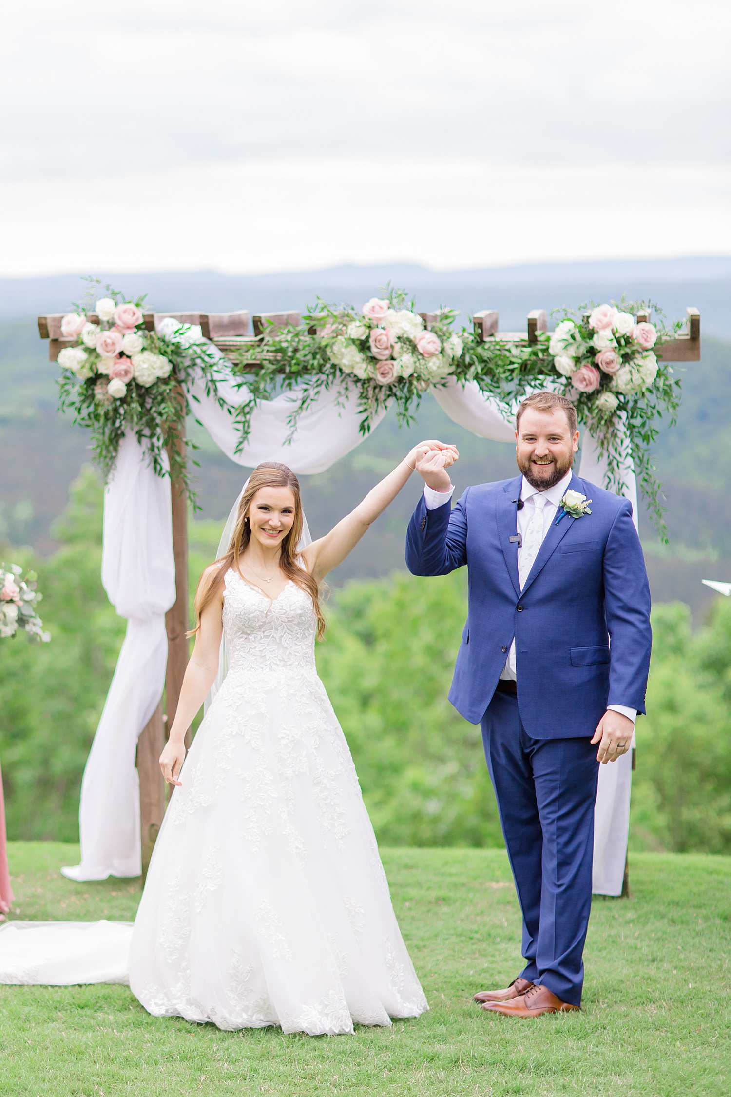newlyweds raise the hands up in celebration of marriage after Romantic Spring Wedding at Weddings at Cabin Bluff