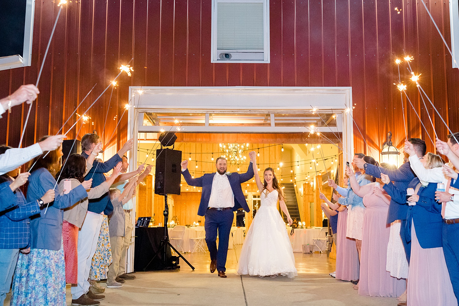 husband and wife exit the red barn at the end of their wedding night 