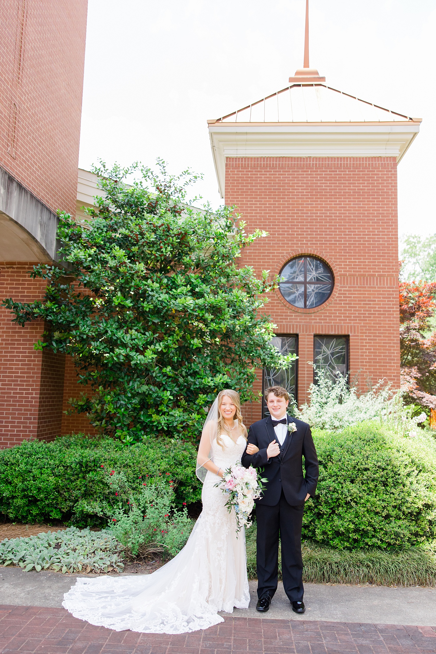 bride and groom in front of St. Francis Xavier Catholic Church 