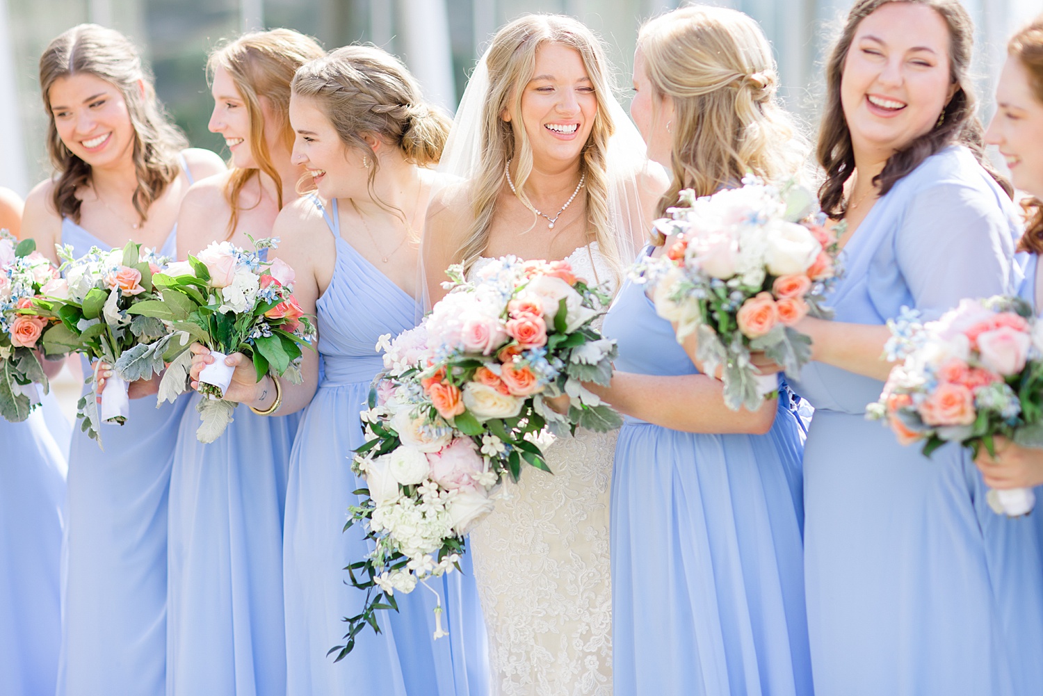 bride and bridesmaids holding classic summer wedding bouquets