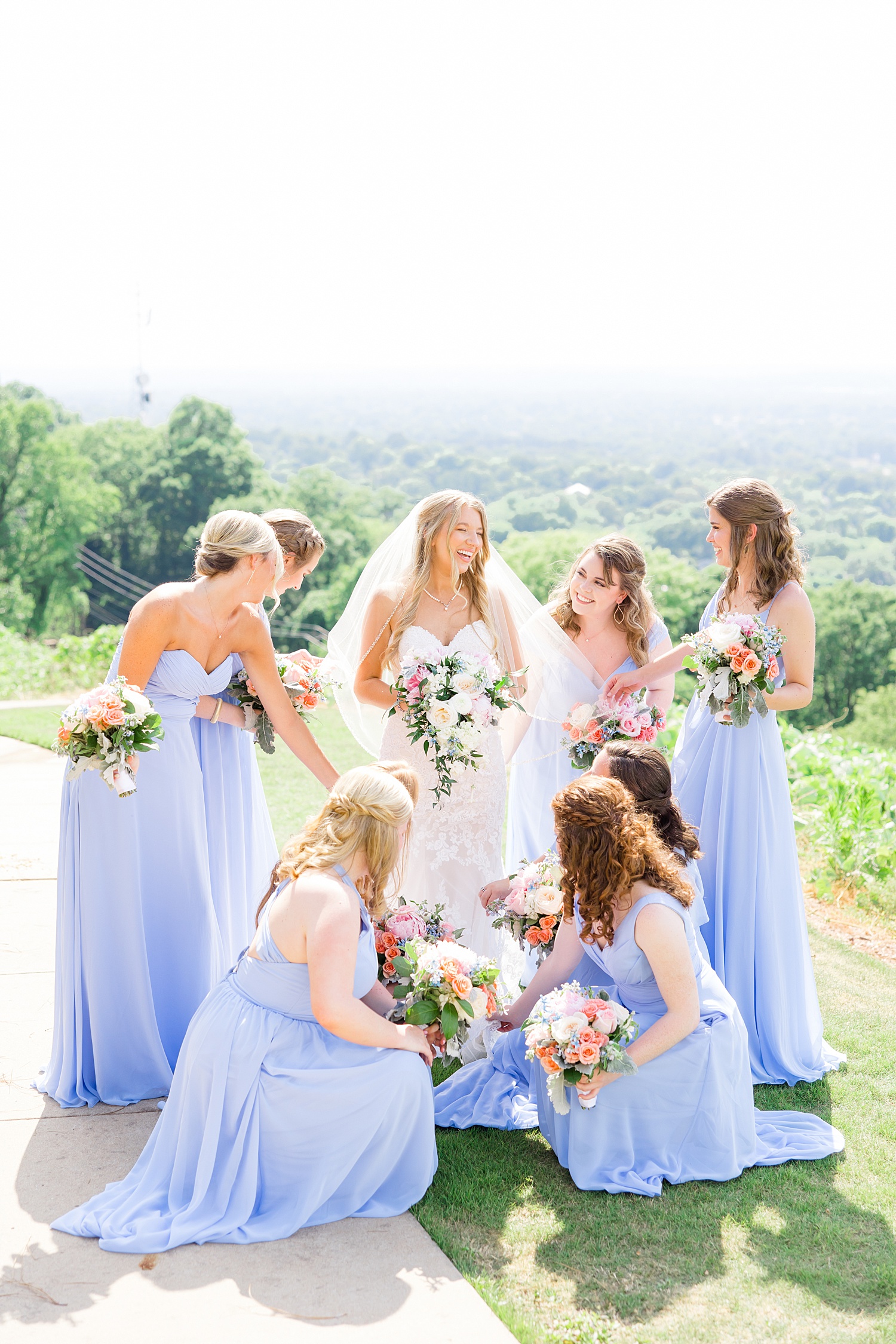 bridesmaids helping bride with dress and veil