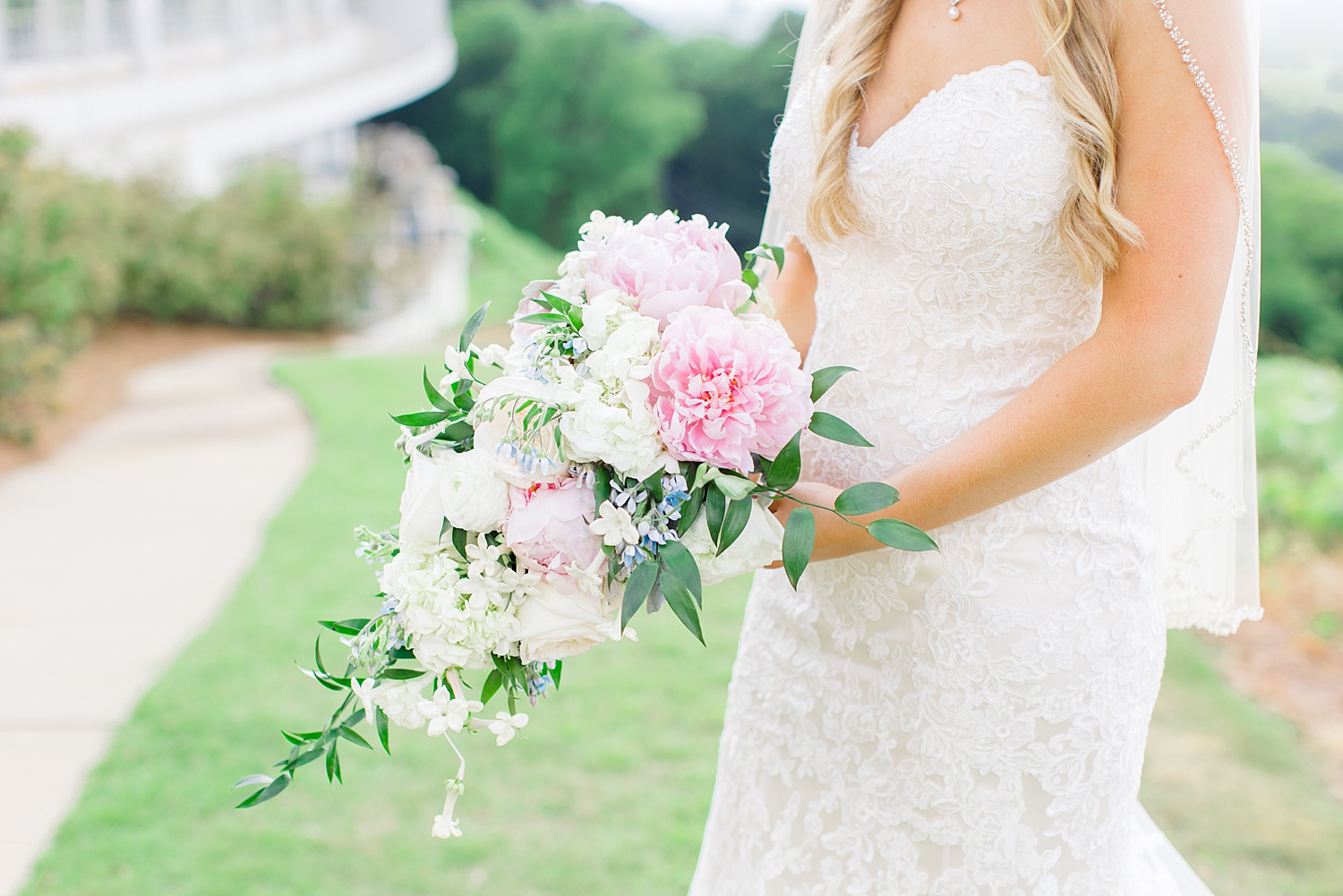 bride holding elegant and classic wedding bouquet of white and pink flowers