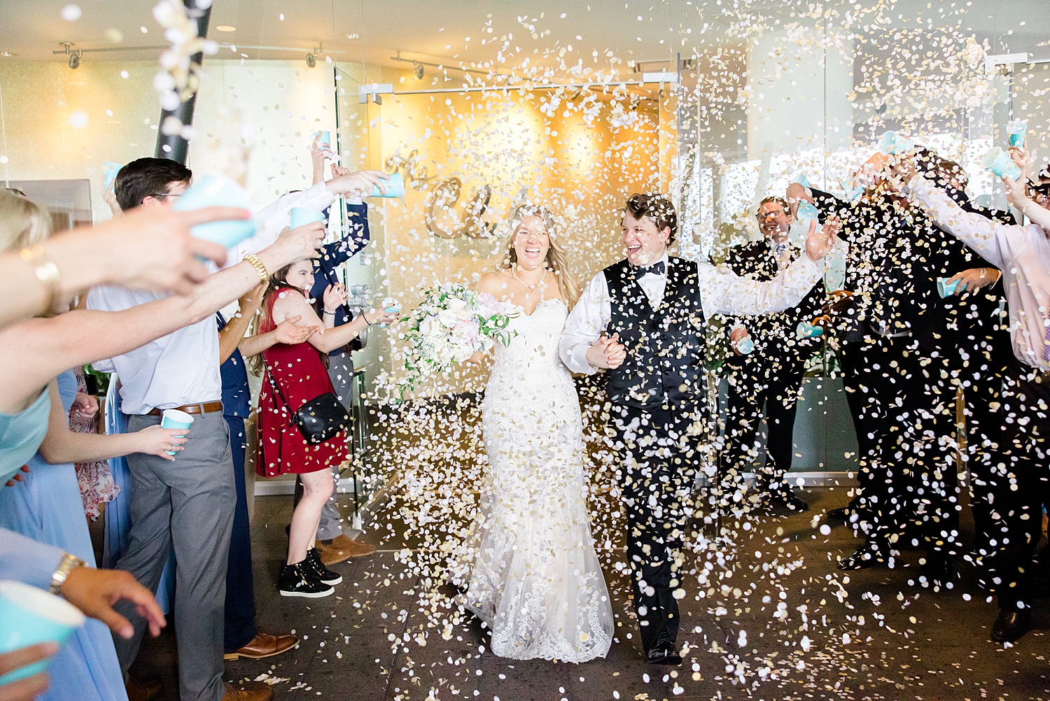 guests throw confetti as newlyweds exit 