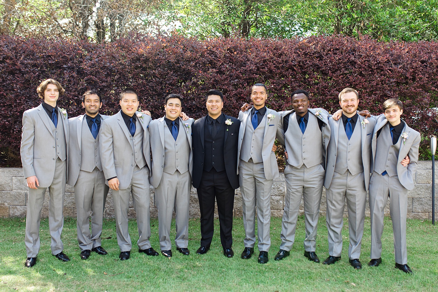 groom and groomsmen with arms around each other 
