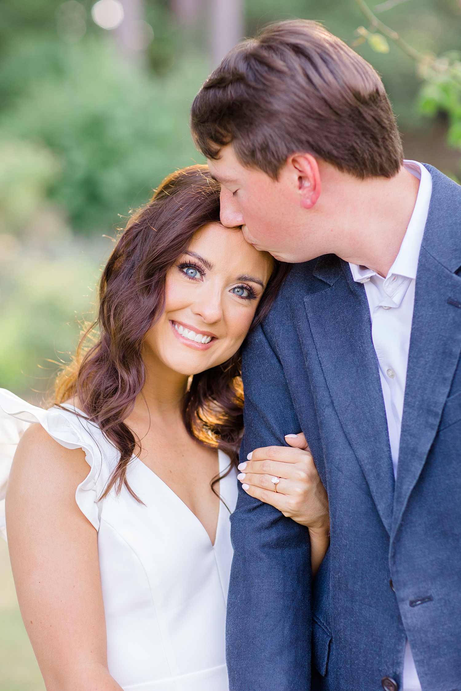 man kisses his fiance's forehead during engagement session